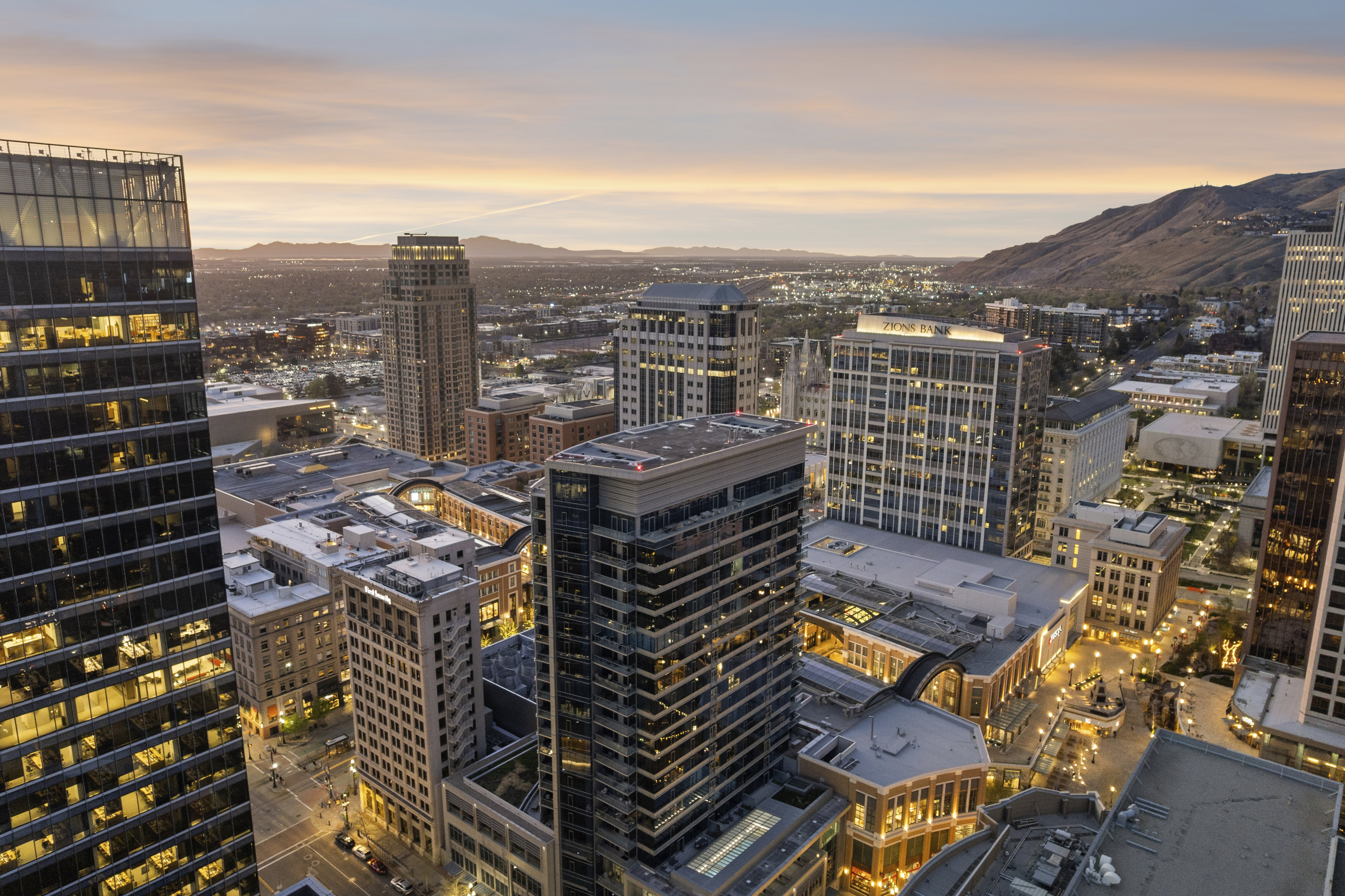 Expansive cityscape featuring modern high-rise buildings and mountain backdrop