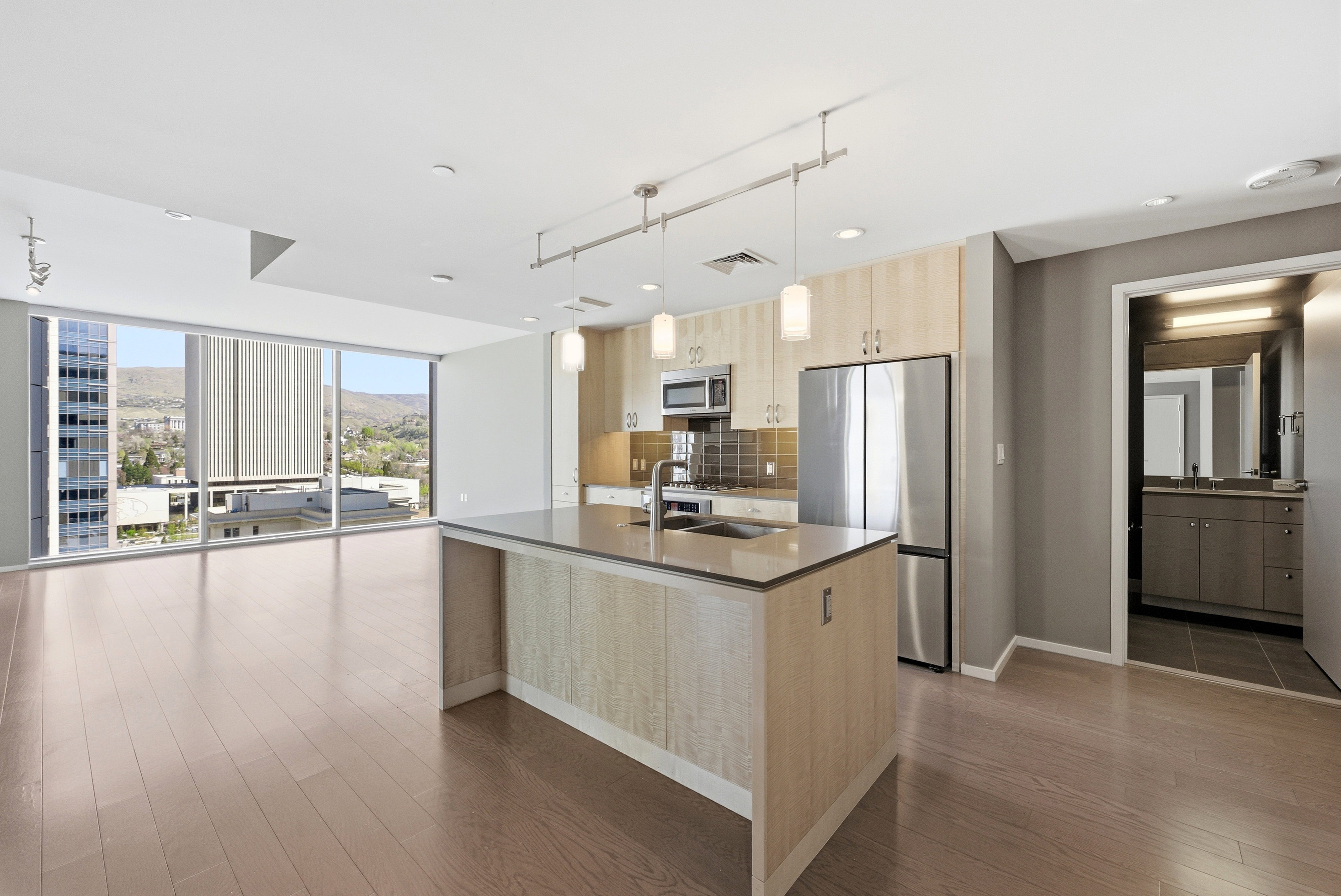 Open-concept living space featuring wood-finish flooring and expansive floor-to-ceiling windows