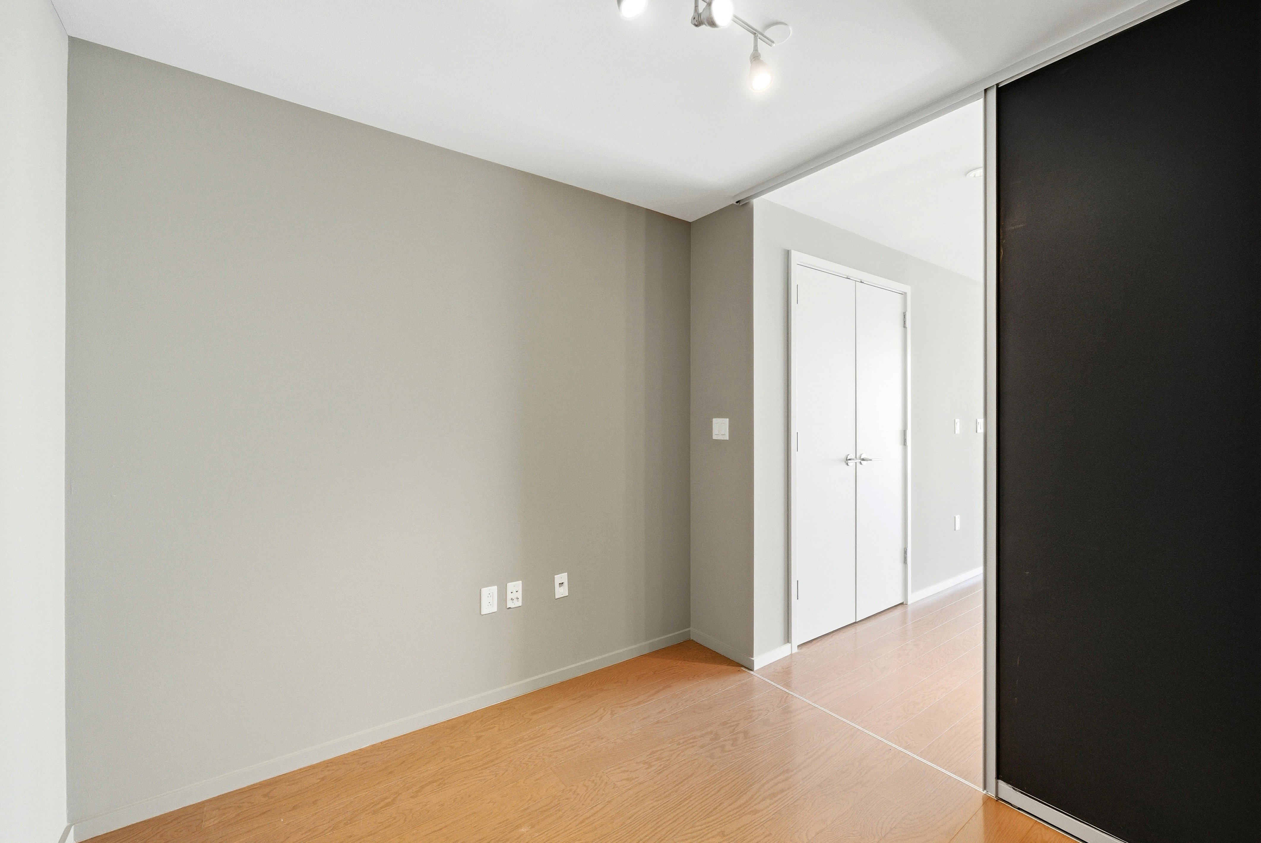 Room featuring wood-finish flooring, recessed lighting, neutral wall tones, and a sliding door