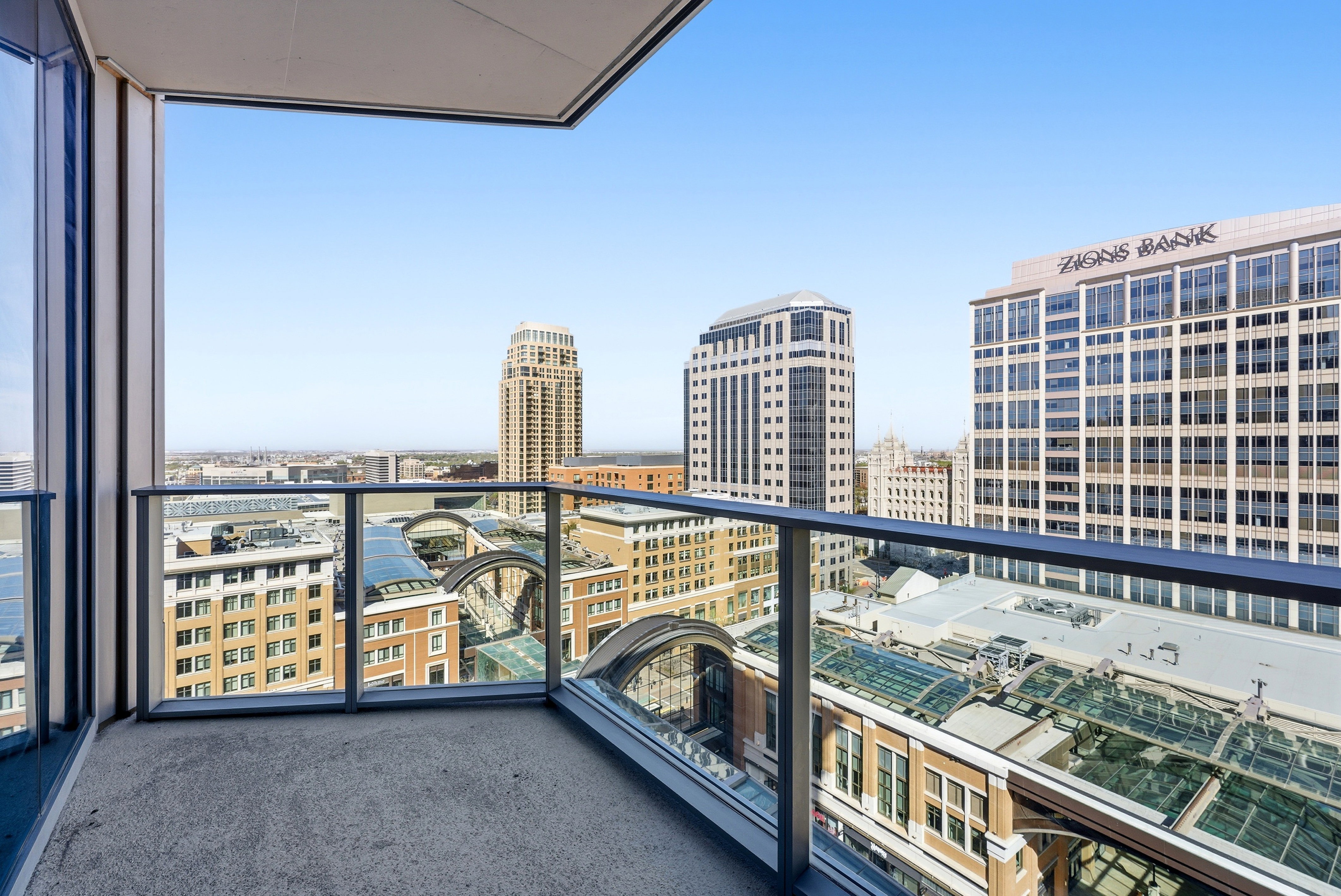 Private balcony featuring glass railings and urban skyline views