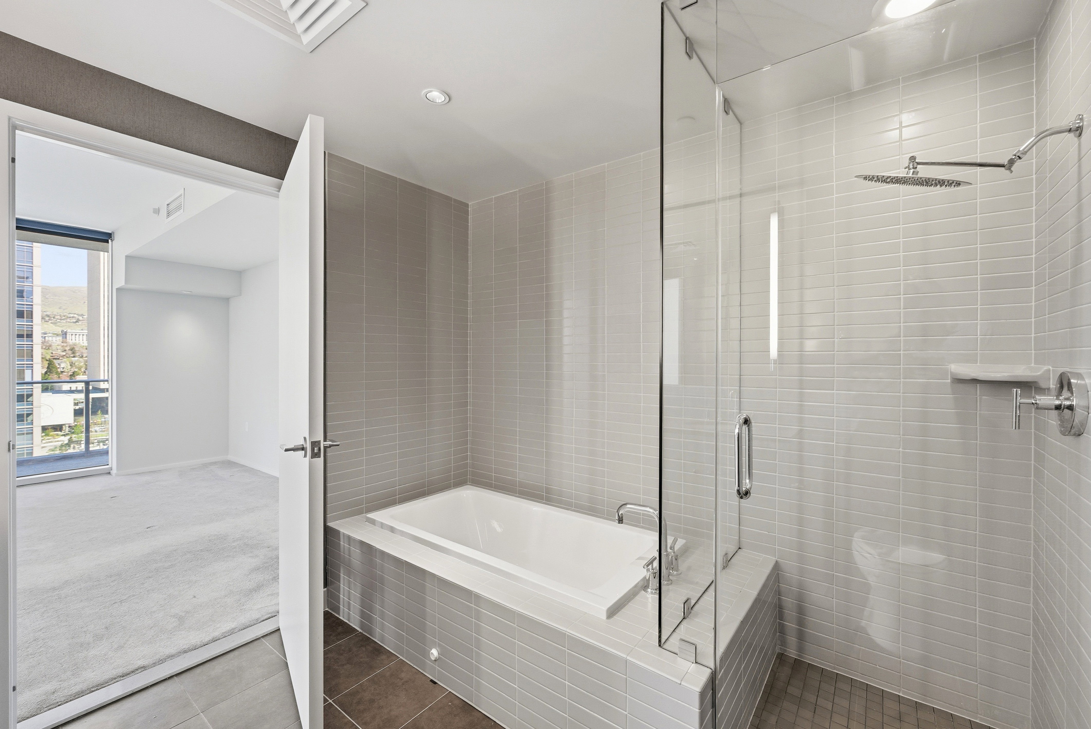 Bathroom featuring a built-in soaking tub and a glass-enclosed shower with a rainfall showerhead