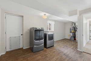 Utility area featuring wood-finish flooring, a window with white trim, and a ceiling-mounted light fixture
