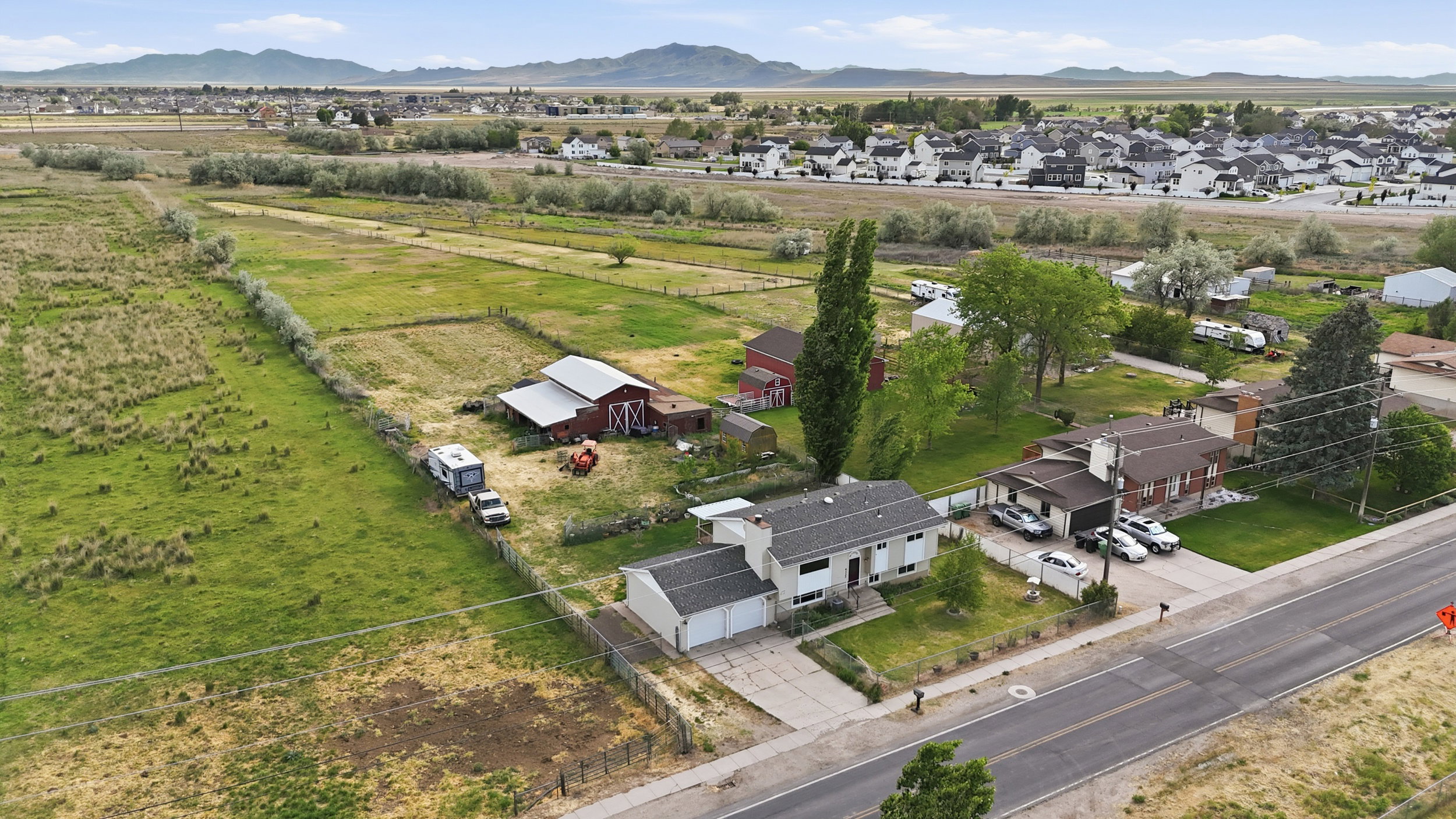 Expansive agricultural land featuring a red barn and secondary outbuilding