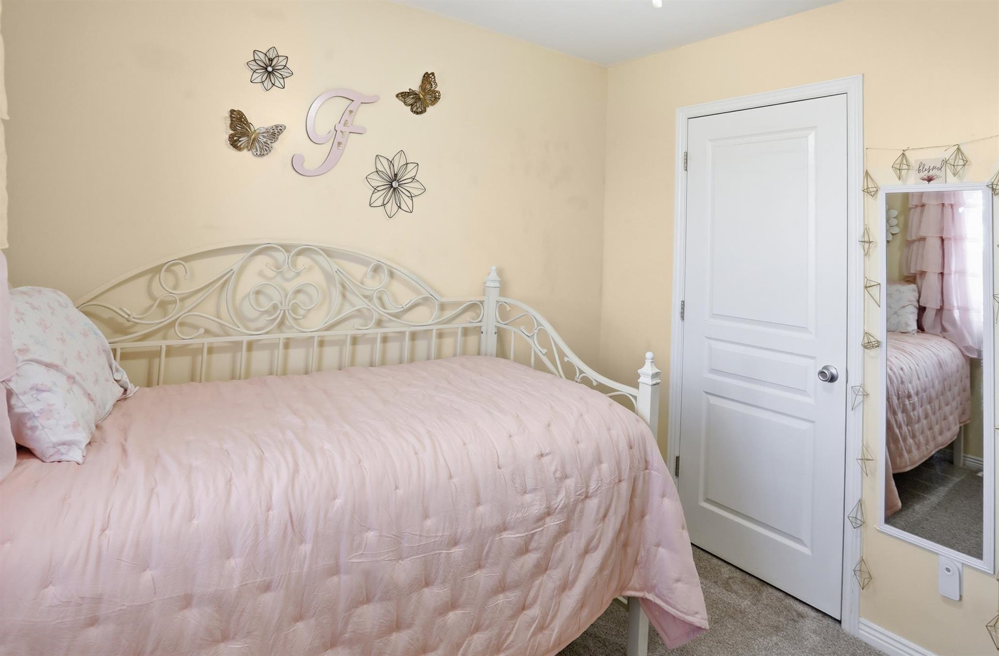 Interior room featuring soft yellow wall paint and grey carpet flooring