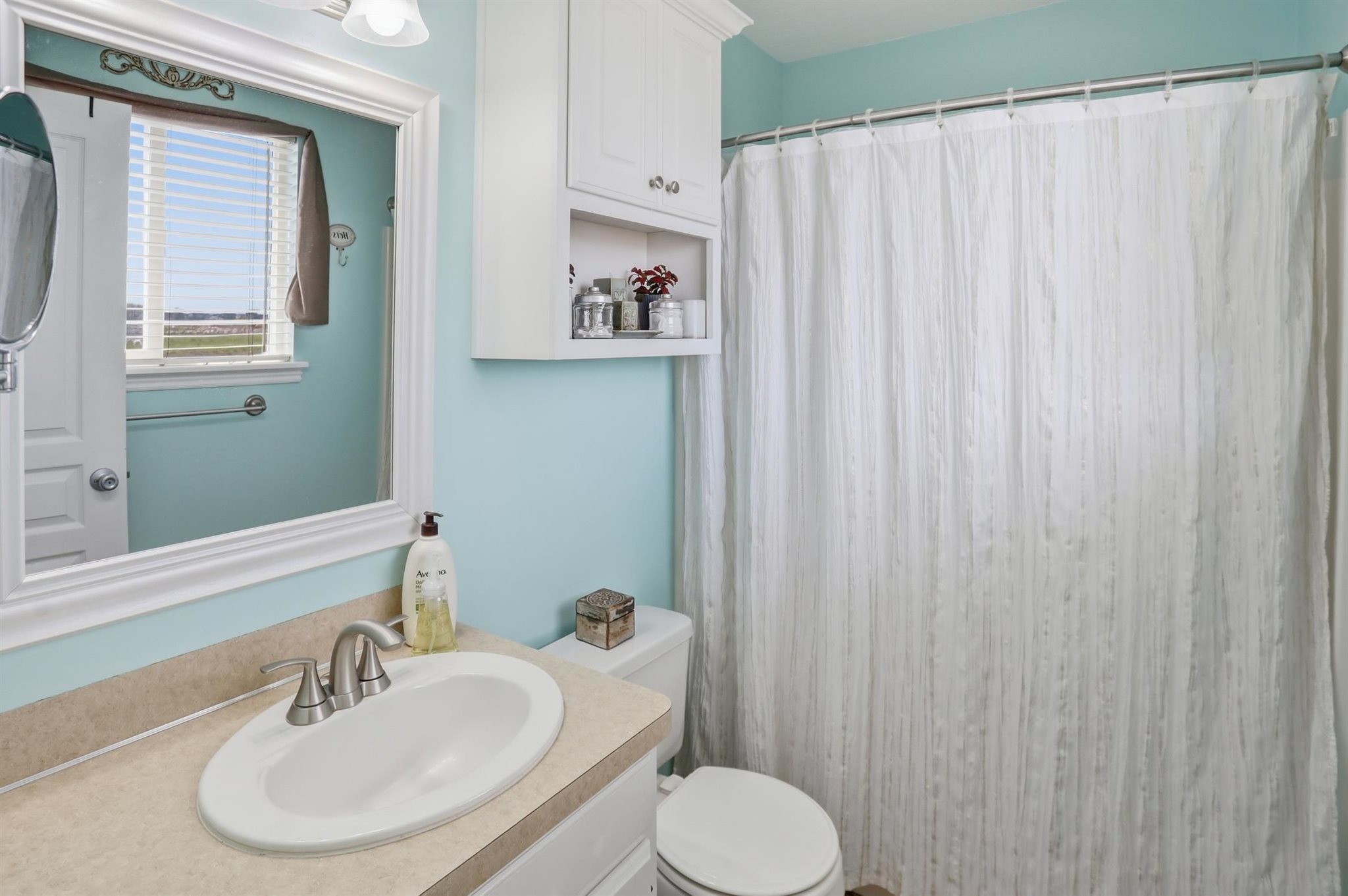Primary Bathroom featuring a vanity with a drop-in sink, brushed nickel faucet, and a light-toned countertop