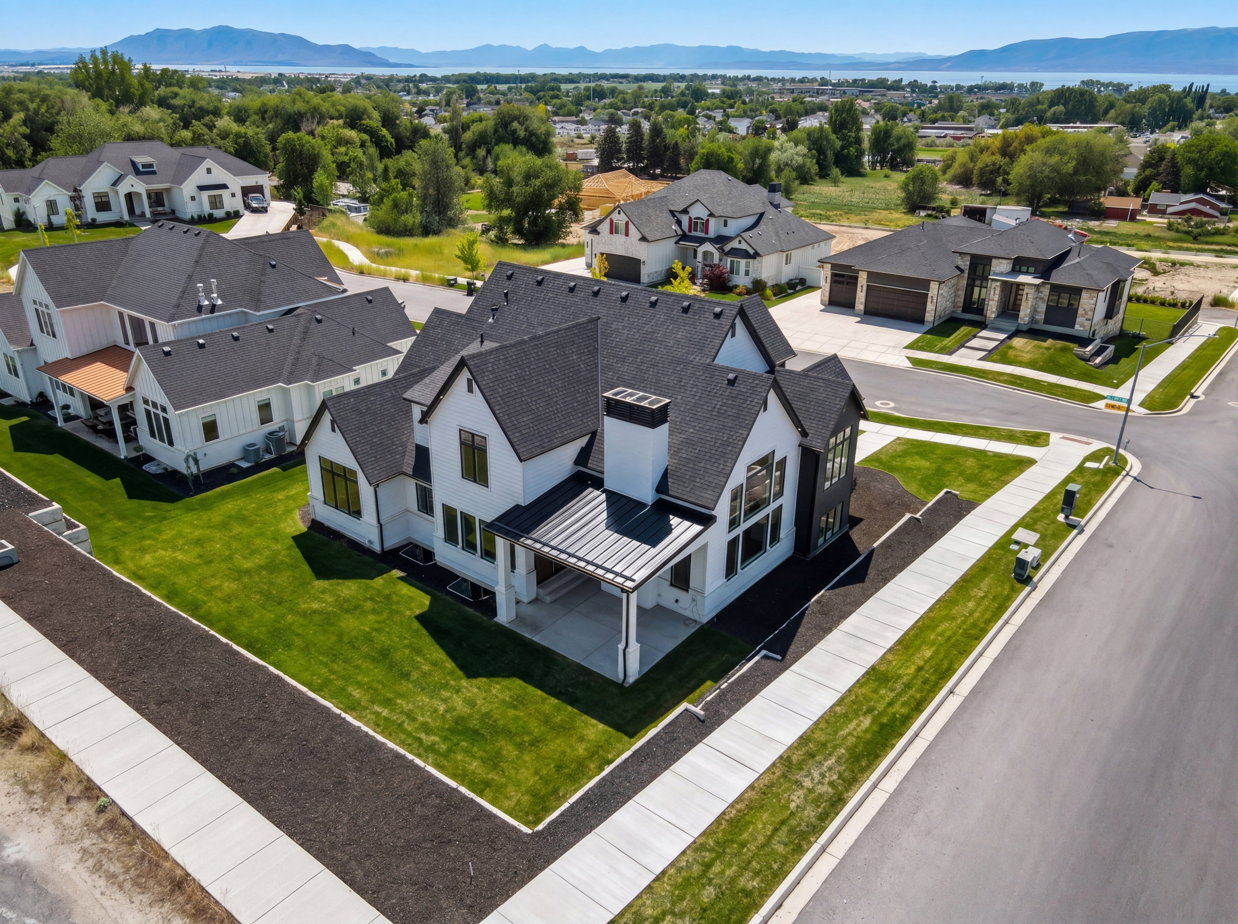 Contemporary residence featuring a black asphalt shingle roof, white siding, and dark window frames