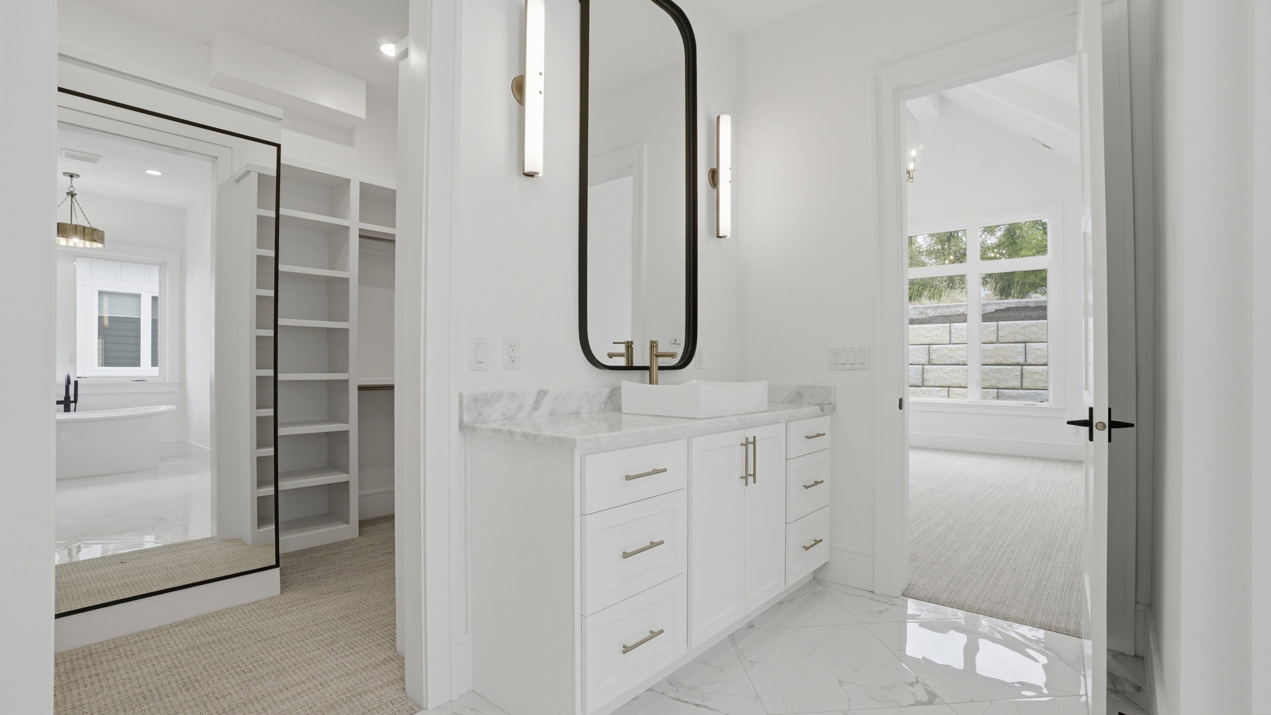 Contemporary vanity featuring a vessel sink with a wall-mounted faucet, a rectangular mirror, and sconce lighting