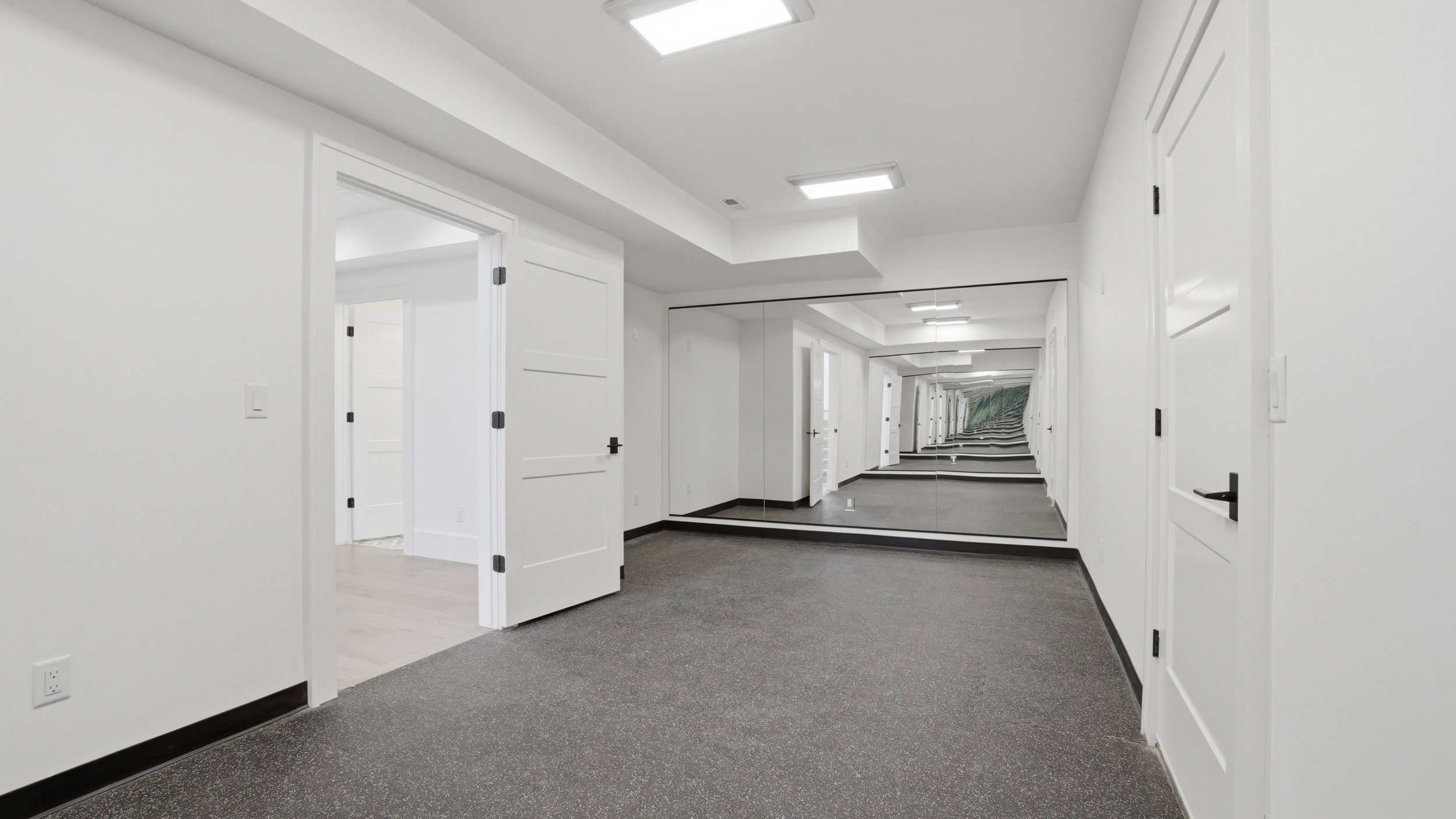 Hallway featuring a full-wall mirror, recessed lighting, and durable flooring