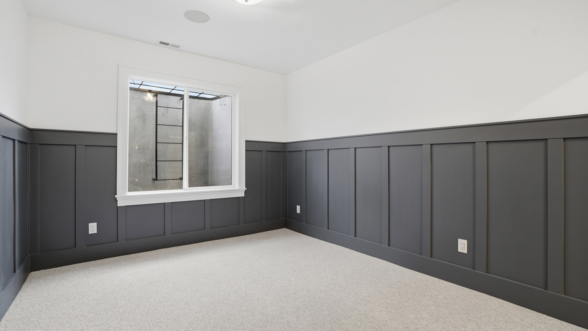 Room featuring board and batten wall paneling, light-colored carpeting, a white-framed window, and recessed ceiling lighting