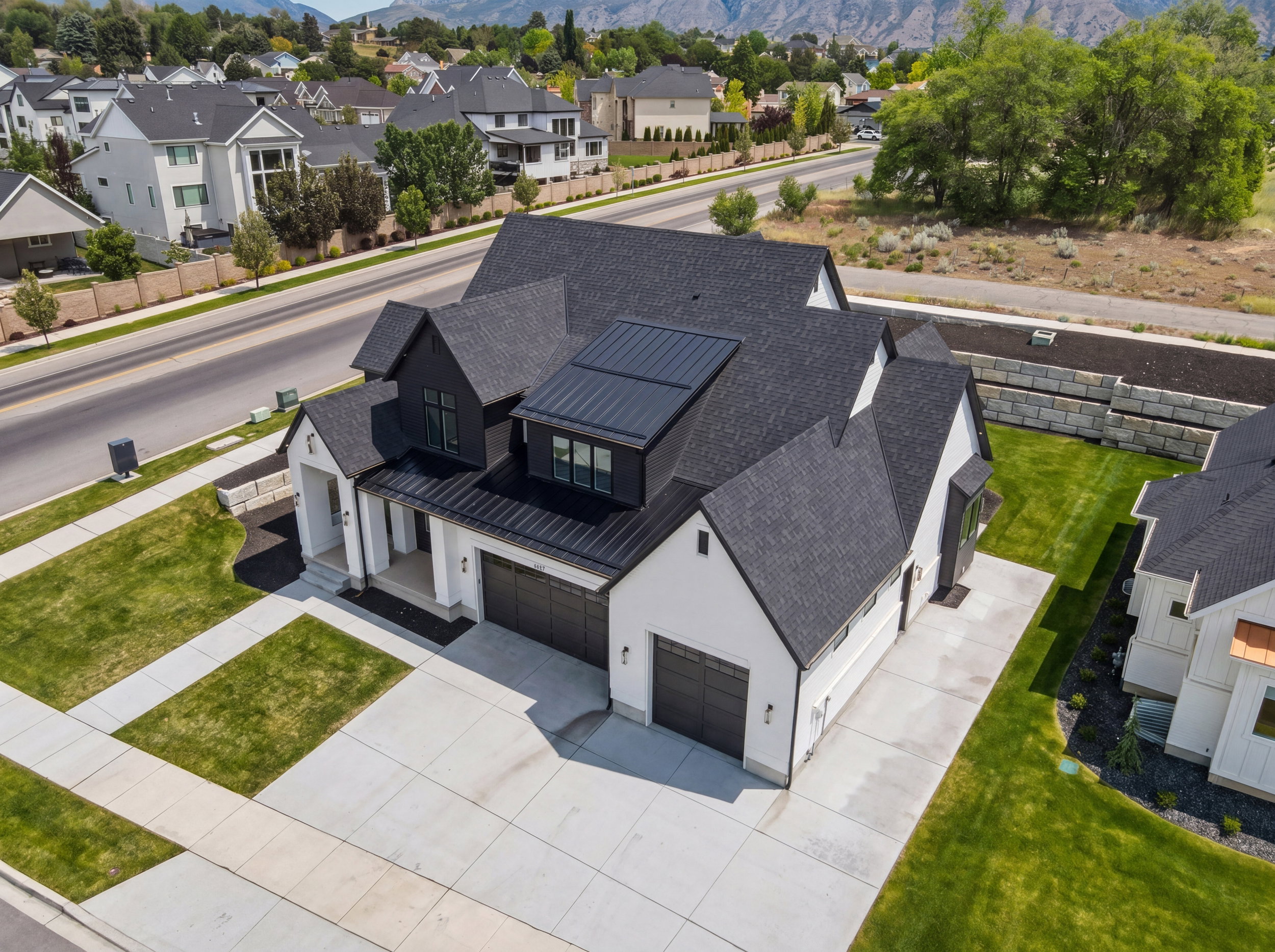 Modern farmhouse exterior featuring a white facade with black trim, multiple gables, and a black shingle roof