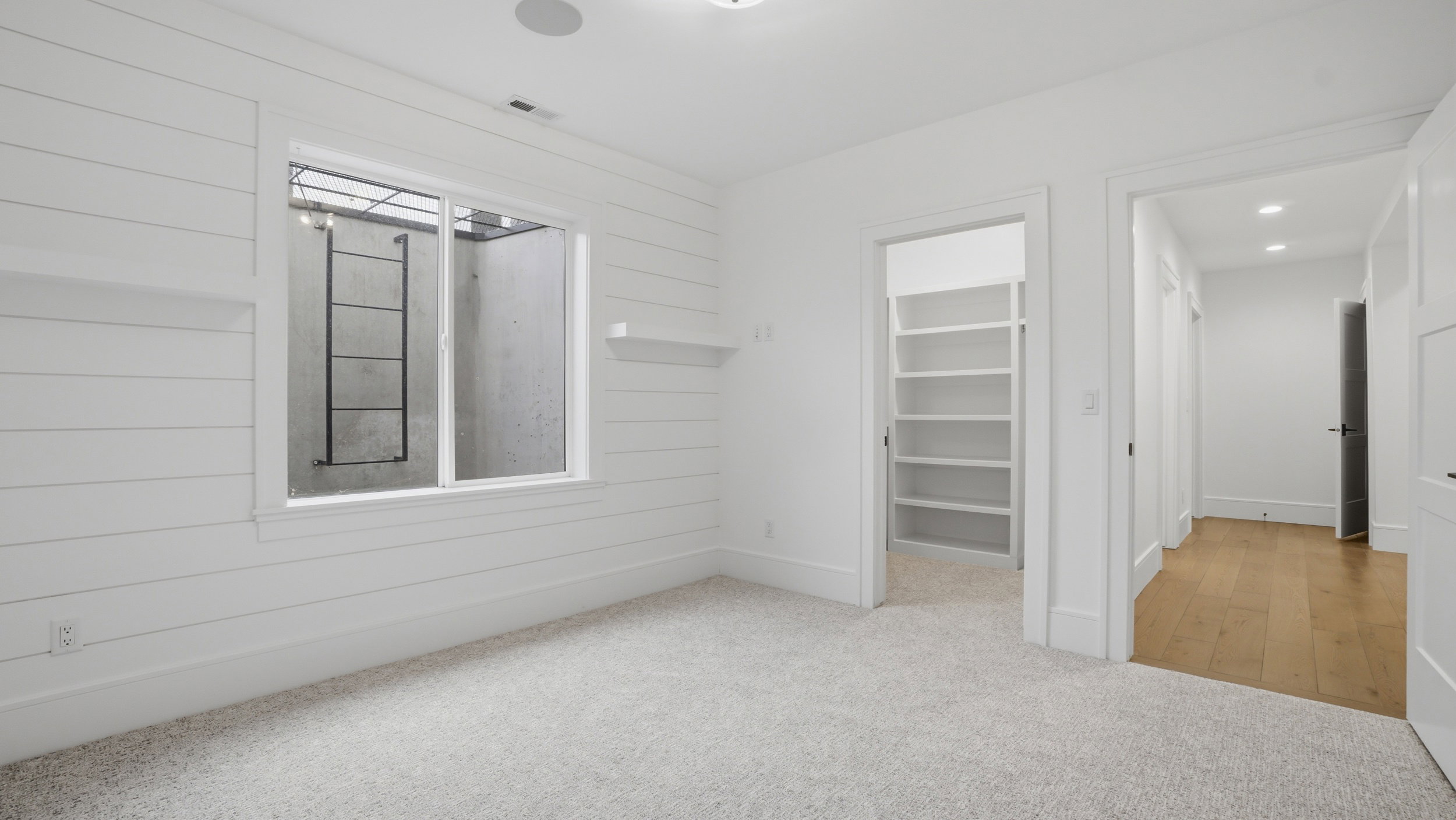 Room featuring light-colored carpeting and shiplap wall finishes