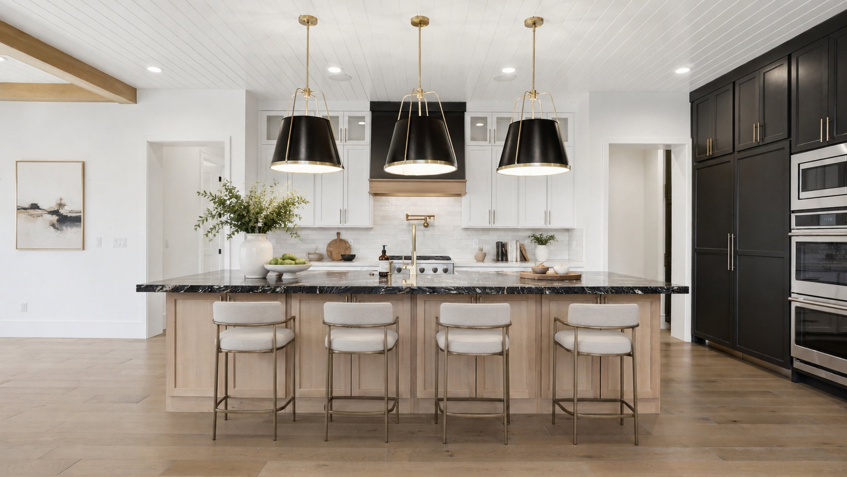 Kitchen featuring a large island with dark stone countertop, light wood-finish cabinetry, and three pendant light fixtures
