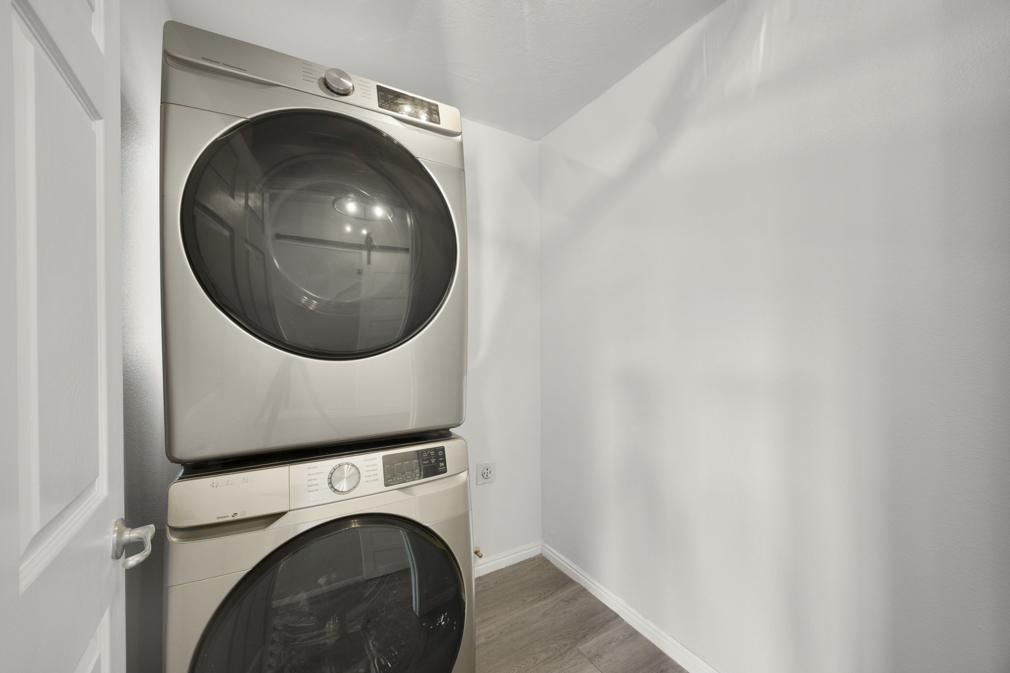 Dedicated laundry area featuring a stacked washer and dryer unit