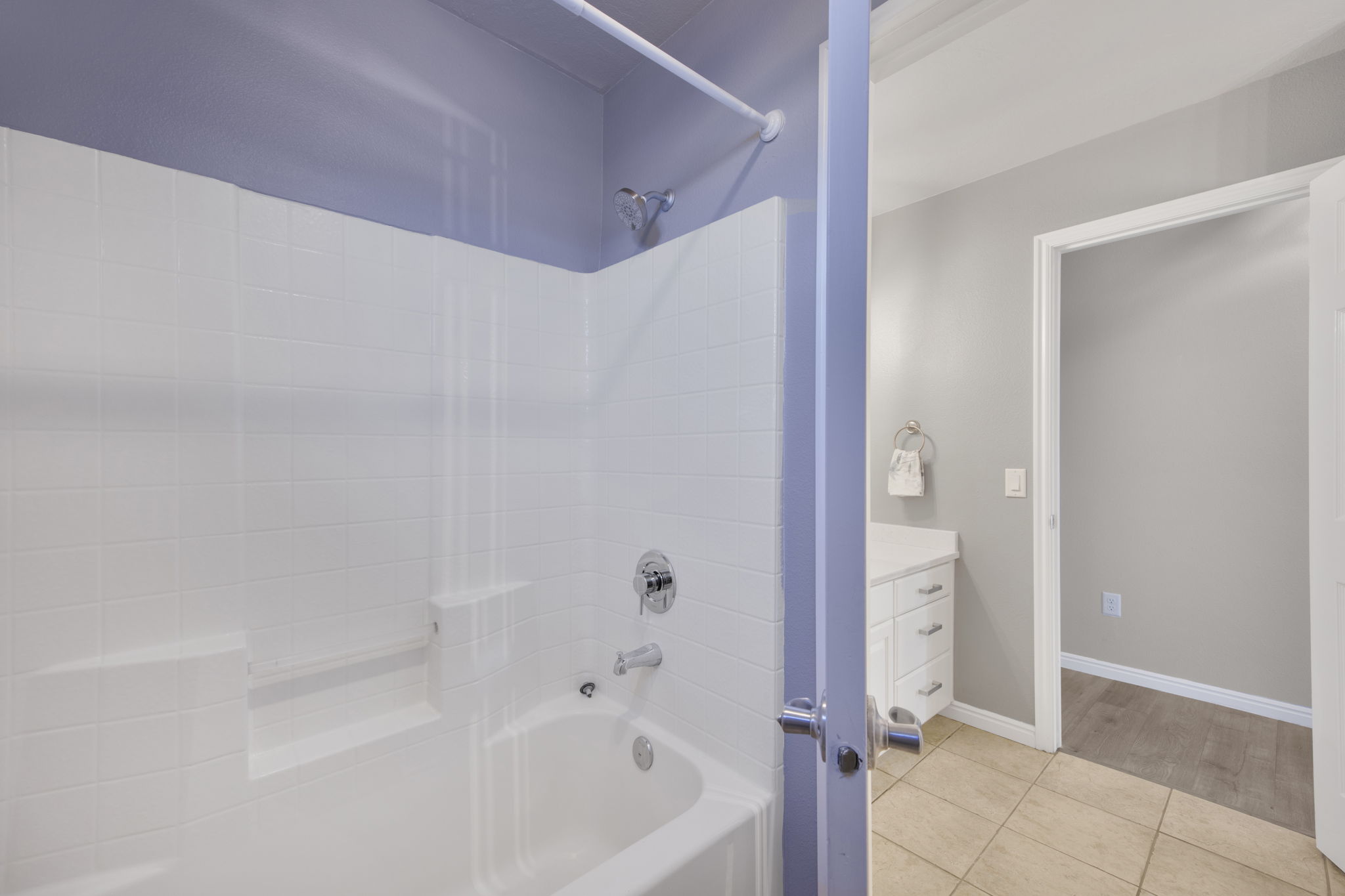 White subway tile shower surround with integrated tub and chrome fixtures