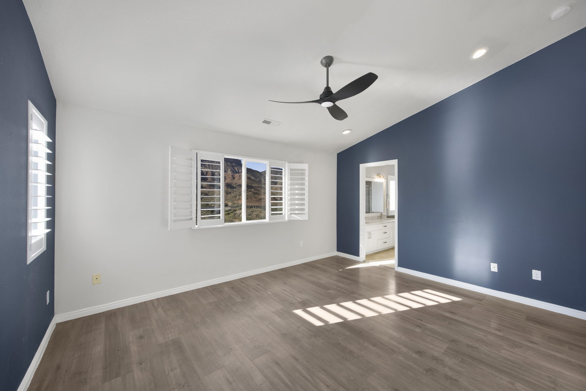 Spacious room featuring wood-finish flooring, a vaulted ceiling, and recessed lighting