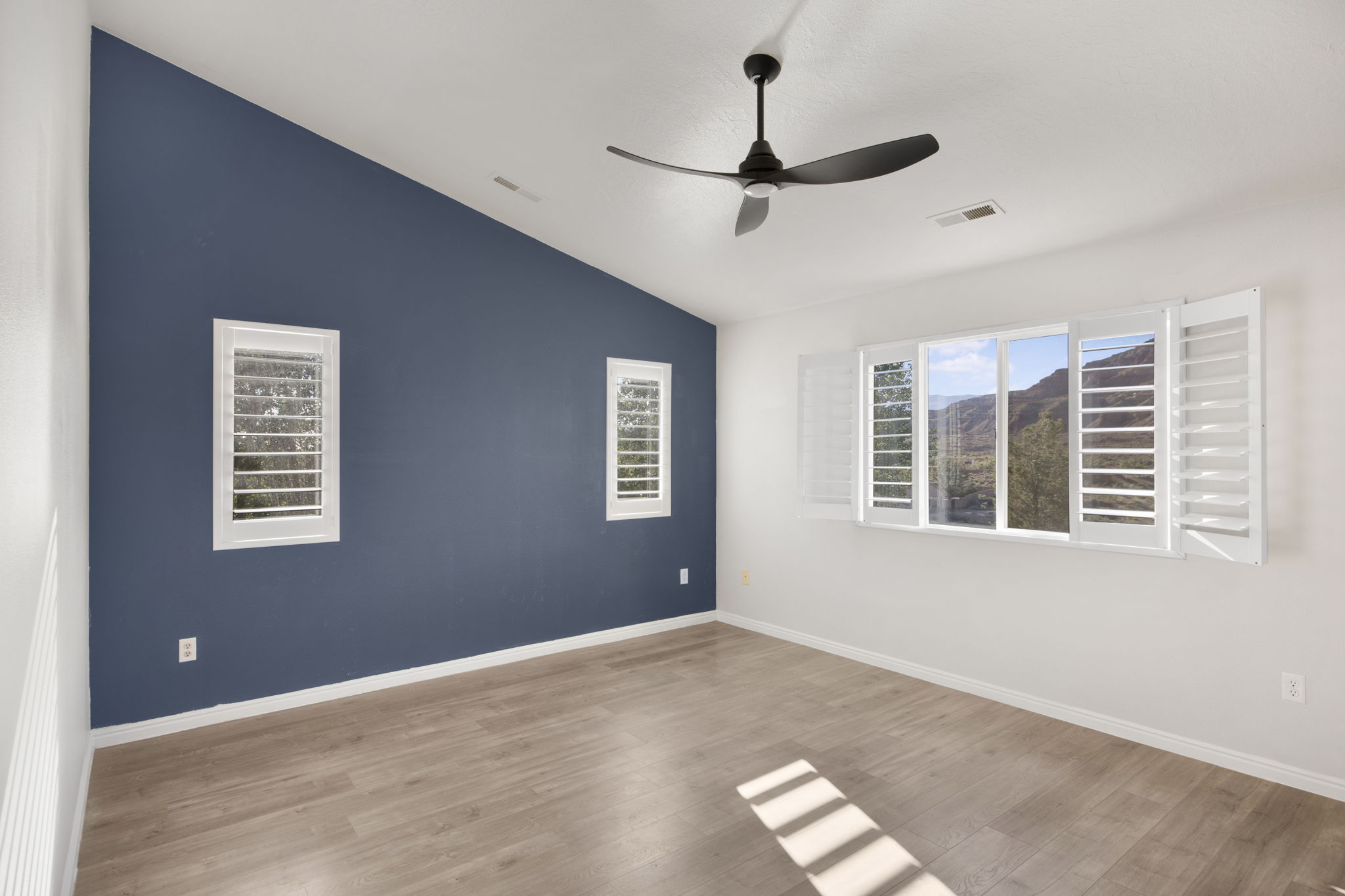 Room with vaulted ceiling, wood-finish flooring, and a ceiling fan