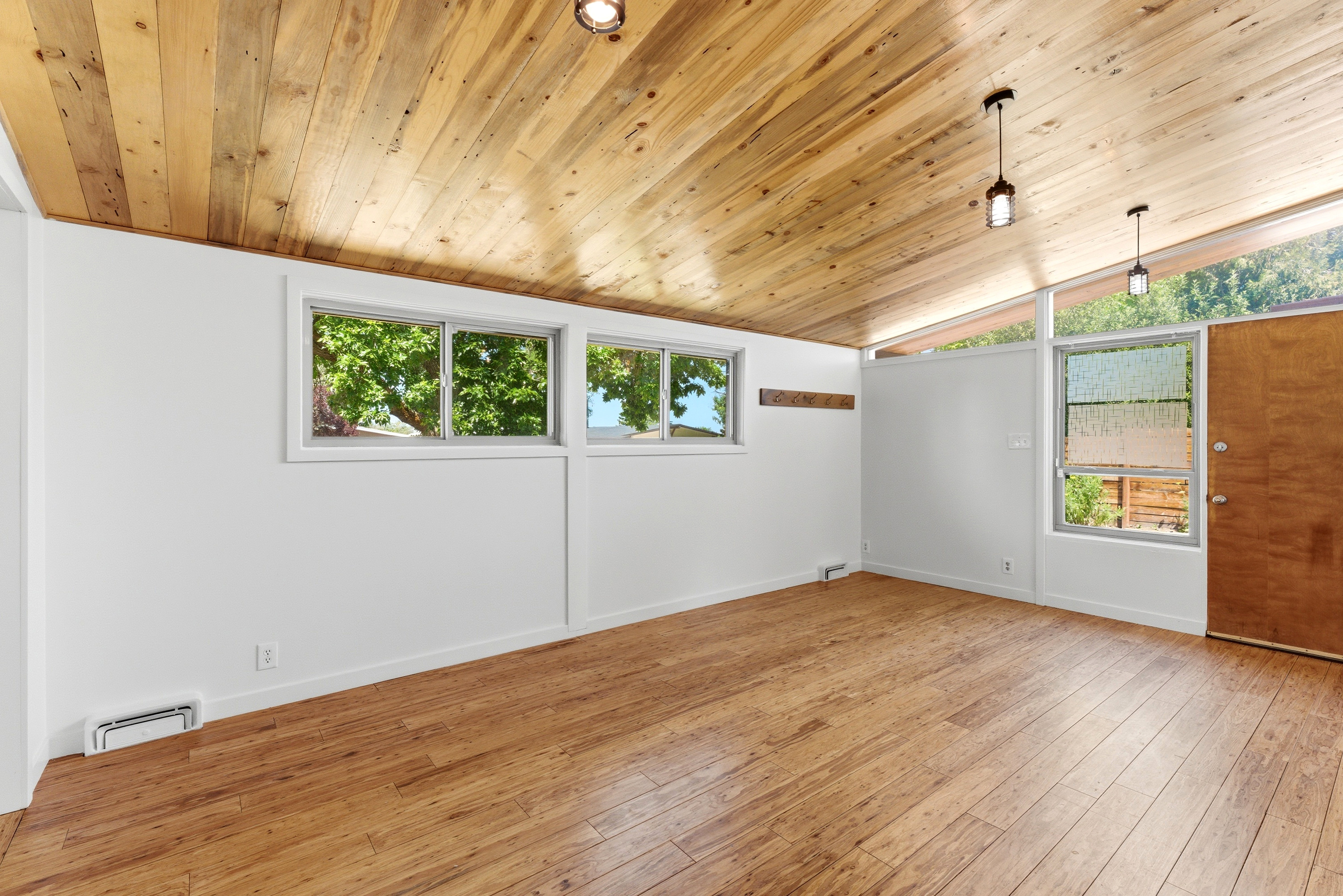 Vaulted wood-paneled ceiling with recessed lighting and pendant fixtures