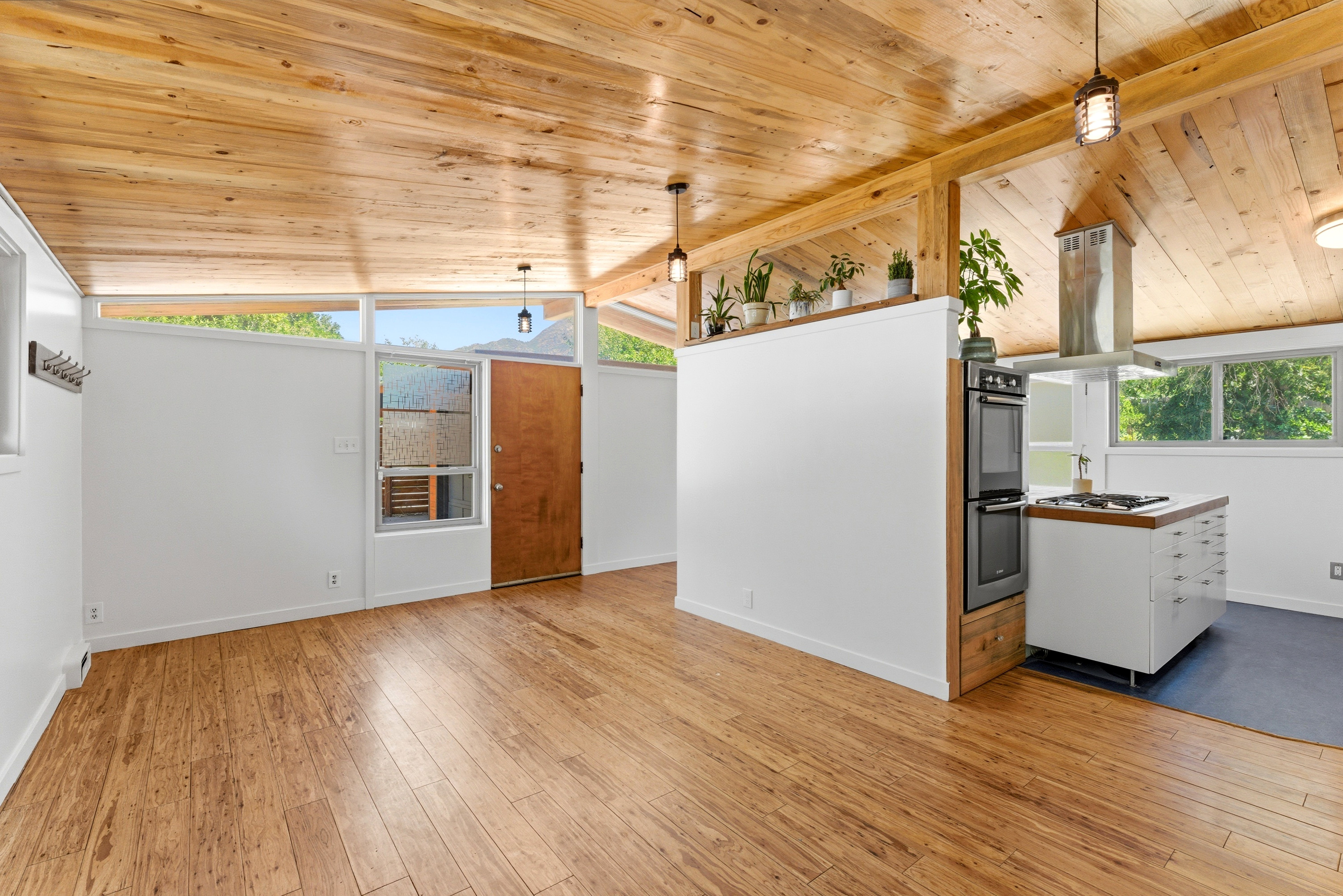 Living area featuring wood-finish flooring, a vaulted wood-plank ceiling, and clerestory windows