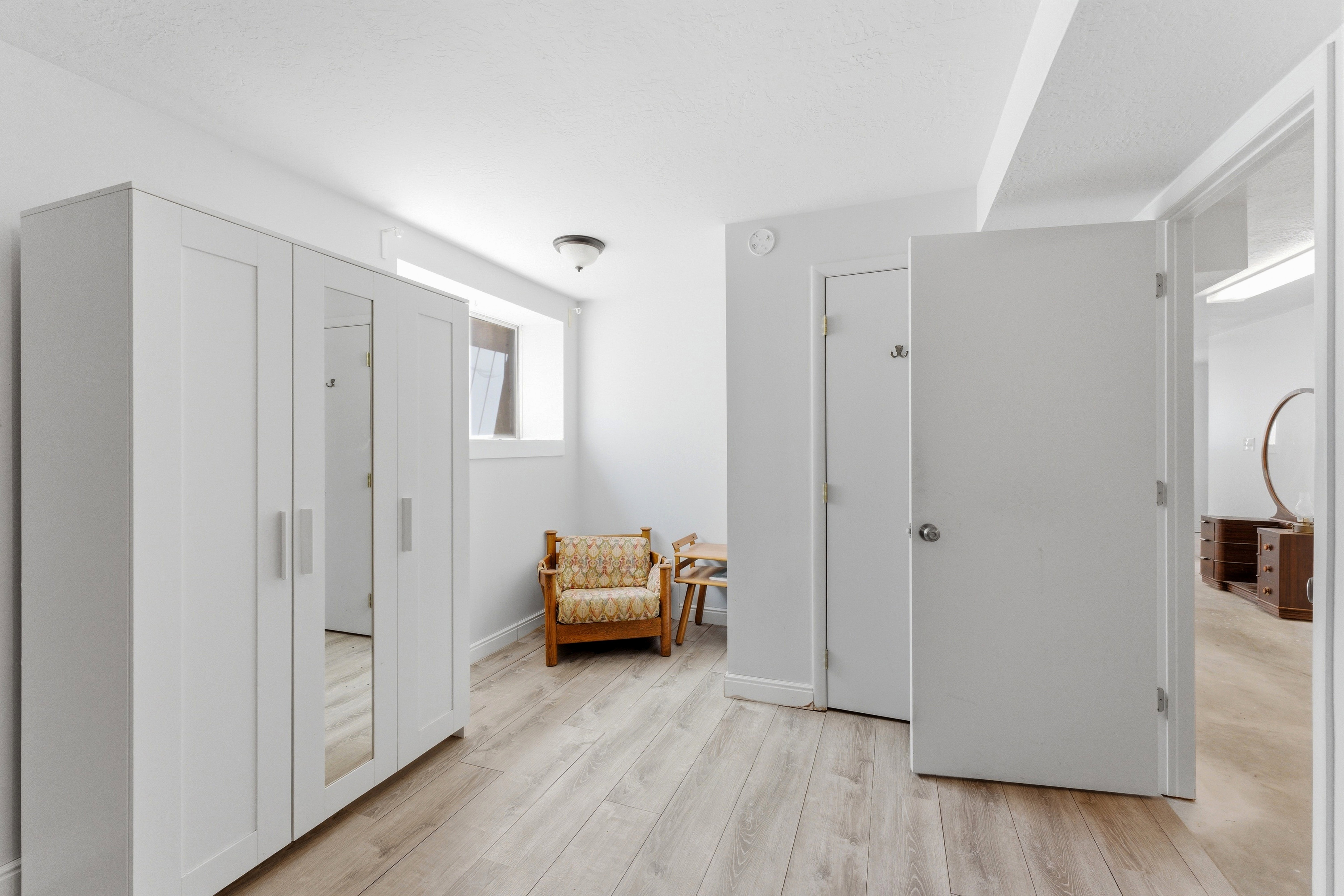 Versatile room featuring light wood-finish flooring, white walls, and a window providing natural light
