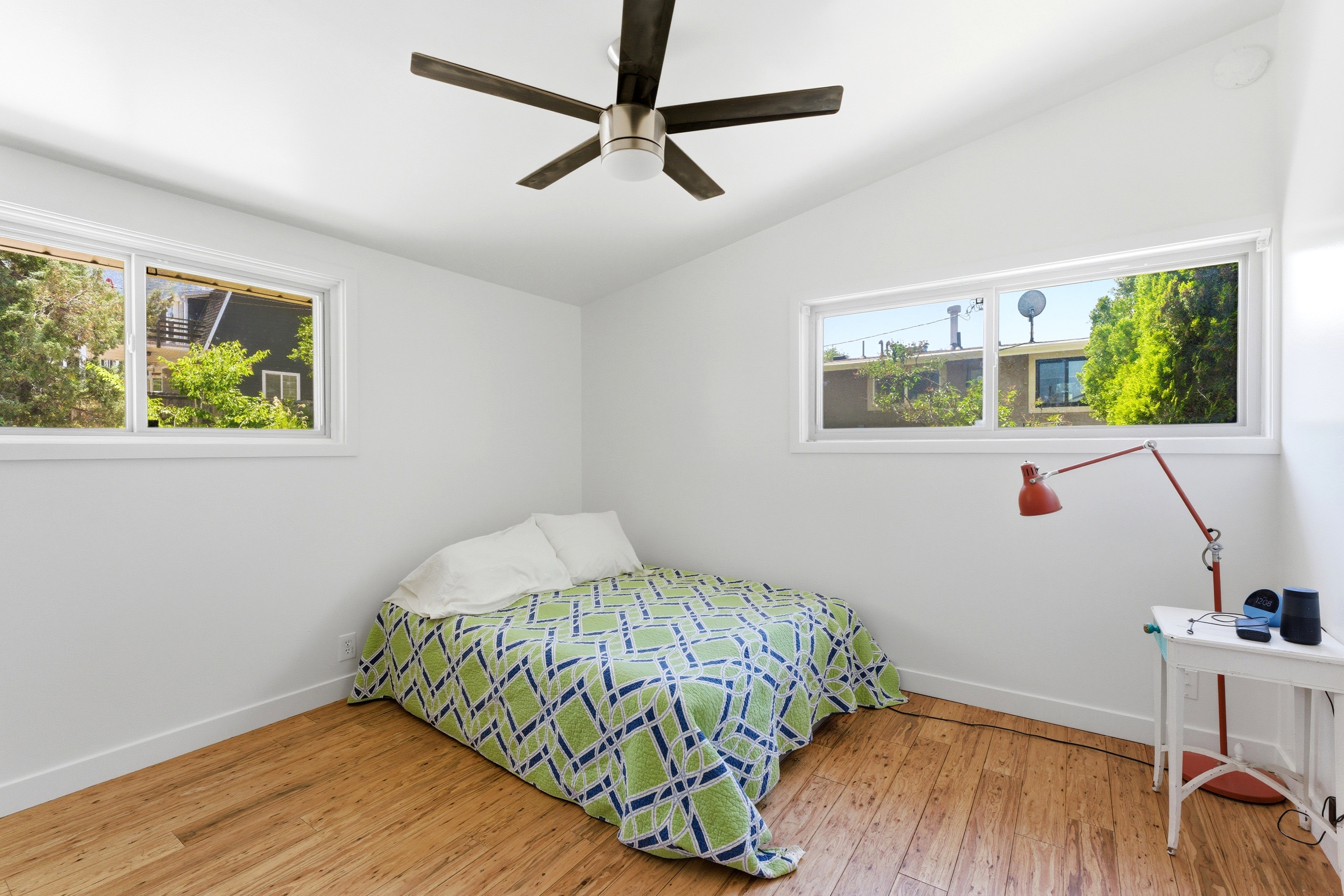 Room featuring wood-finish flooring, white walls, and a vaulted ceiling