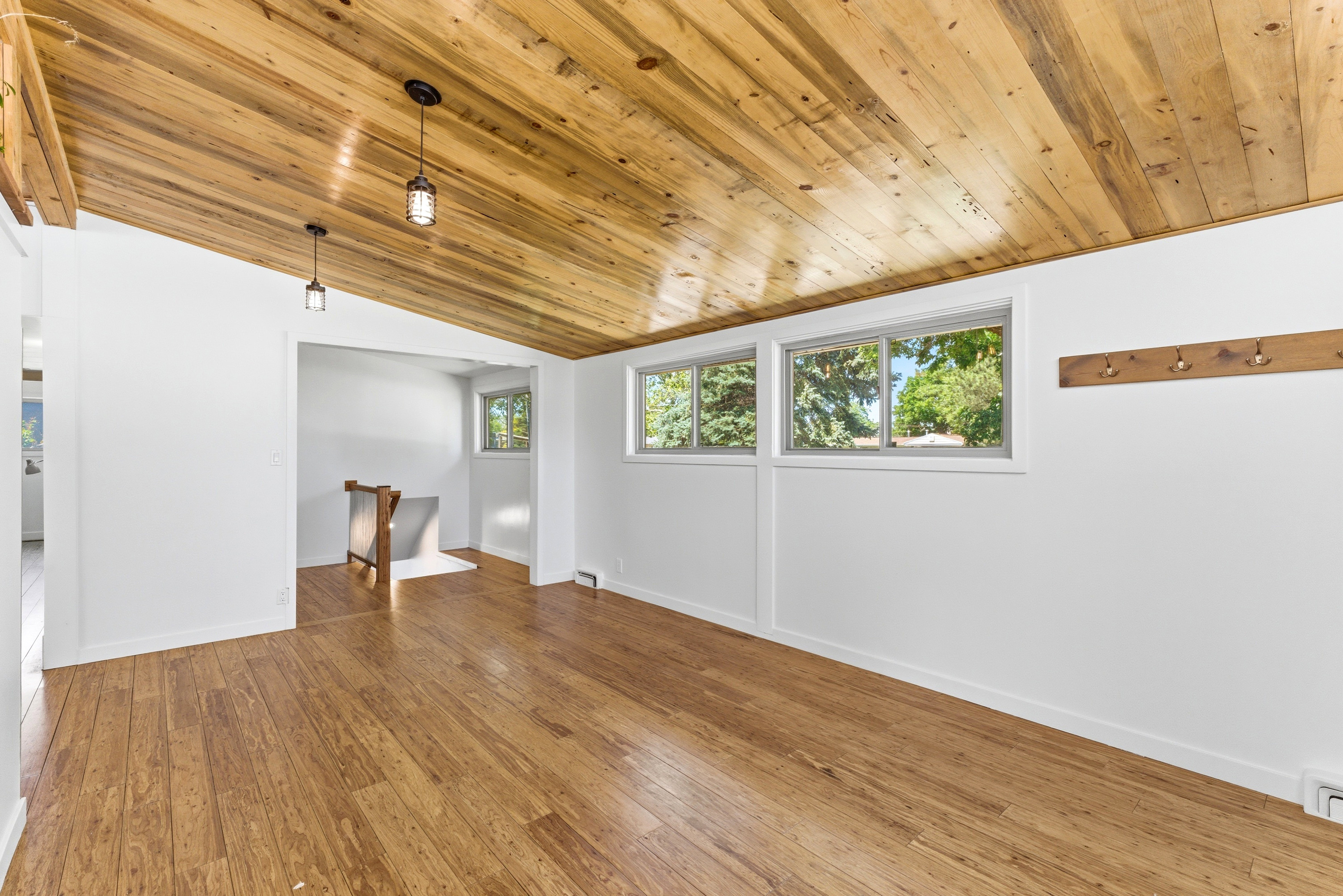 Vaulted wood-plank ceiling featuring two pendant light fixtures