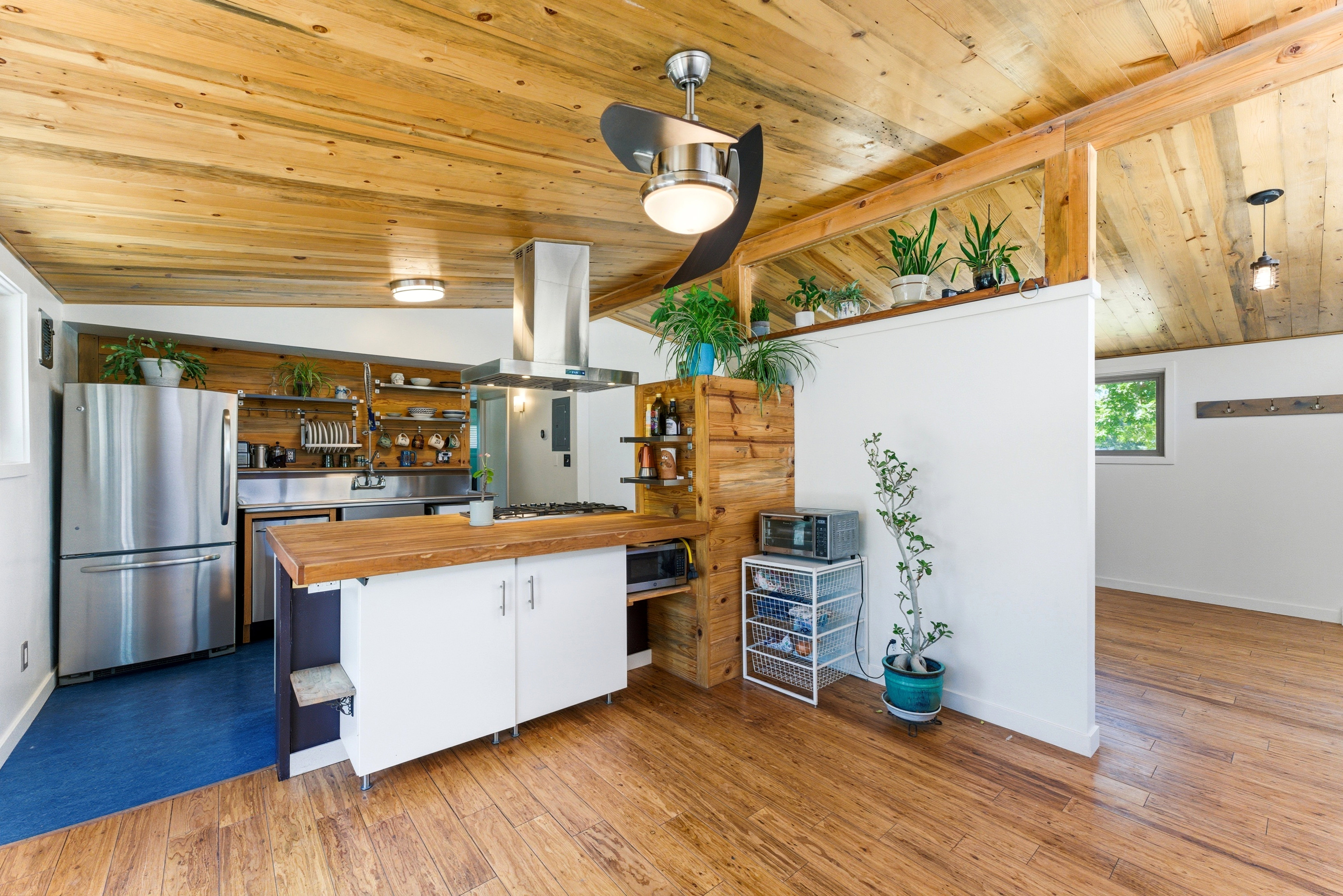 Kitchen featuring wood-finish flooring, stainless steel appliances, and a wood plank ceiling
