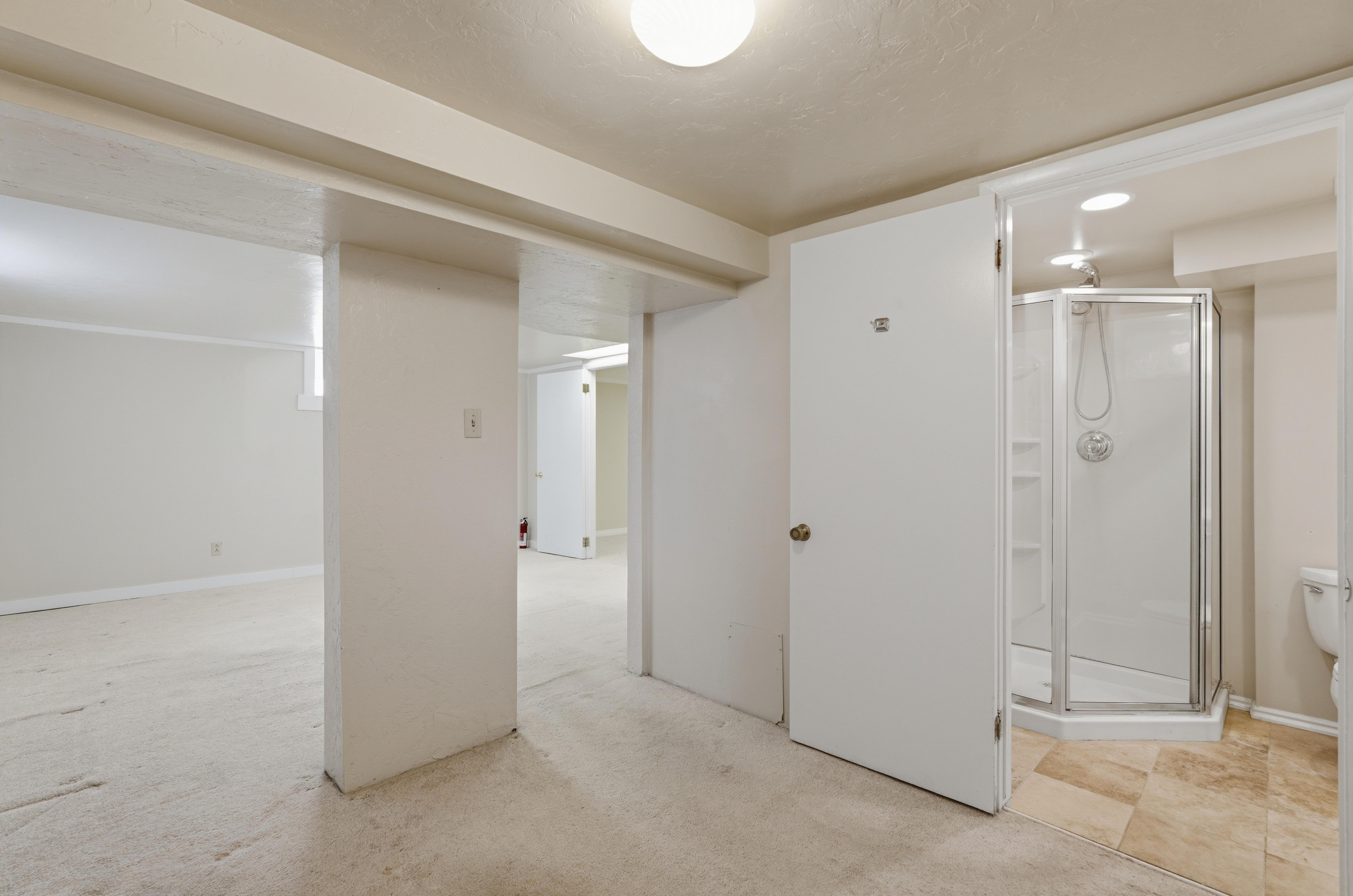 Shower enclosure featuring a glass door and white base