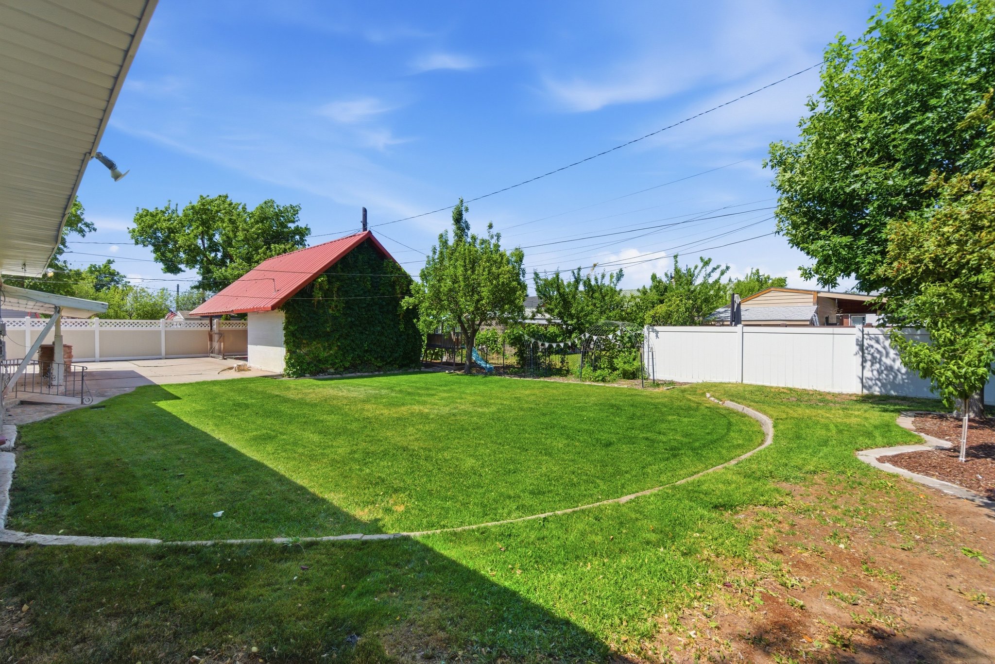 Expansive backyard featuring a manicured lawn and mature trees