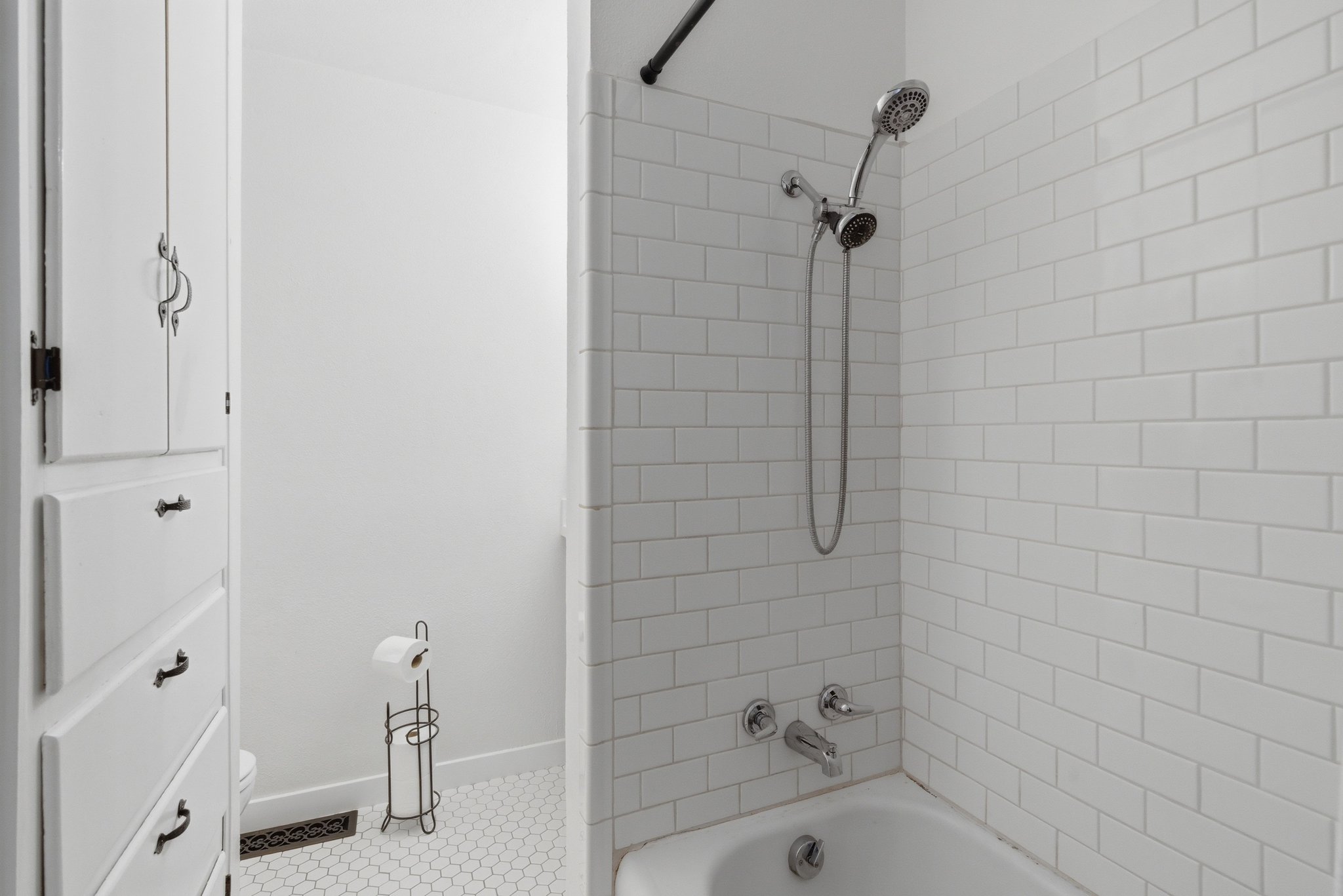 Bathroom with white subway tile shower surround and a white bathtub