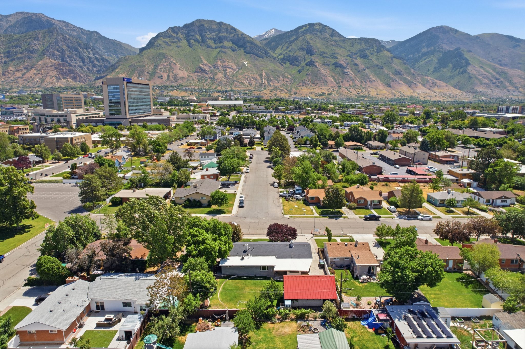 Residential neighborhood featuring varied architectural styles and mature landscaping, with a prominent mountain backdrop