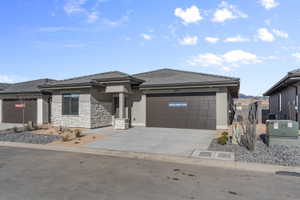 * All photos are of a similar model and finishes*Contemporary single-story residence featuring a stucco and stacked stone facade
