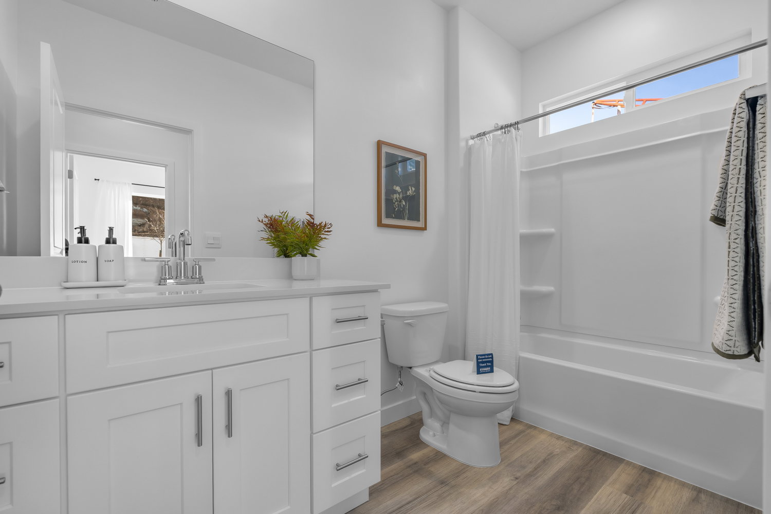 Bathroom featuring a vanity with white cabinetry, a white countertop, and a rectangular undermount sink