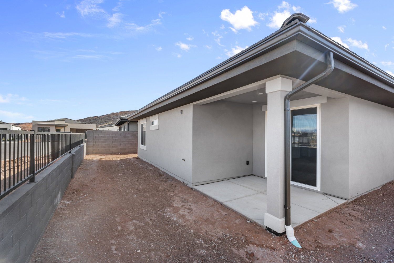 Covered patio with a concrete slab, stucco exterior, and a sliding glass door