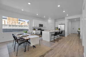 Open-concept kitchen and dining area featuring light wood-finish flooring