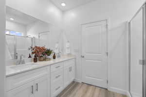 Dual vanity with white cabinetry, quartz-finish countertop, and chrome fixtures