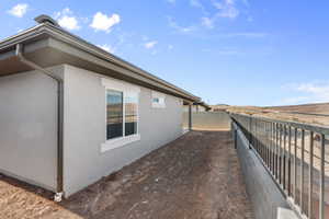 Stucco exterior featuring white-framed windows, dark gutters, and a sloped tile roof