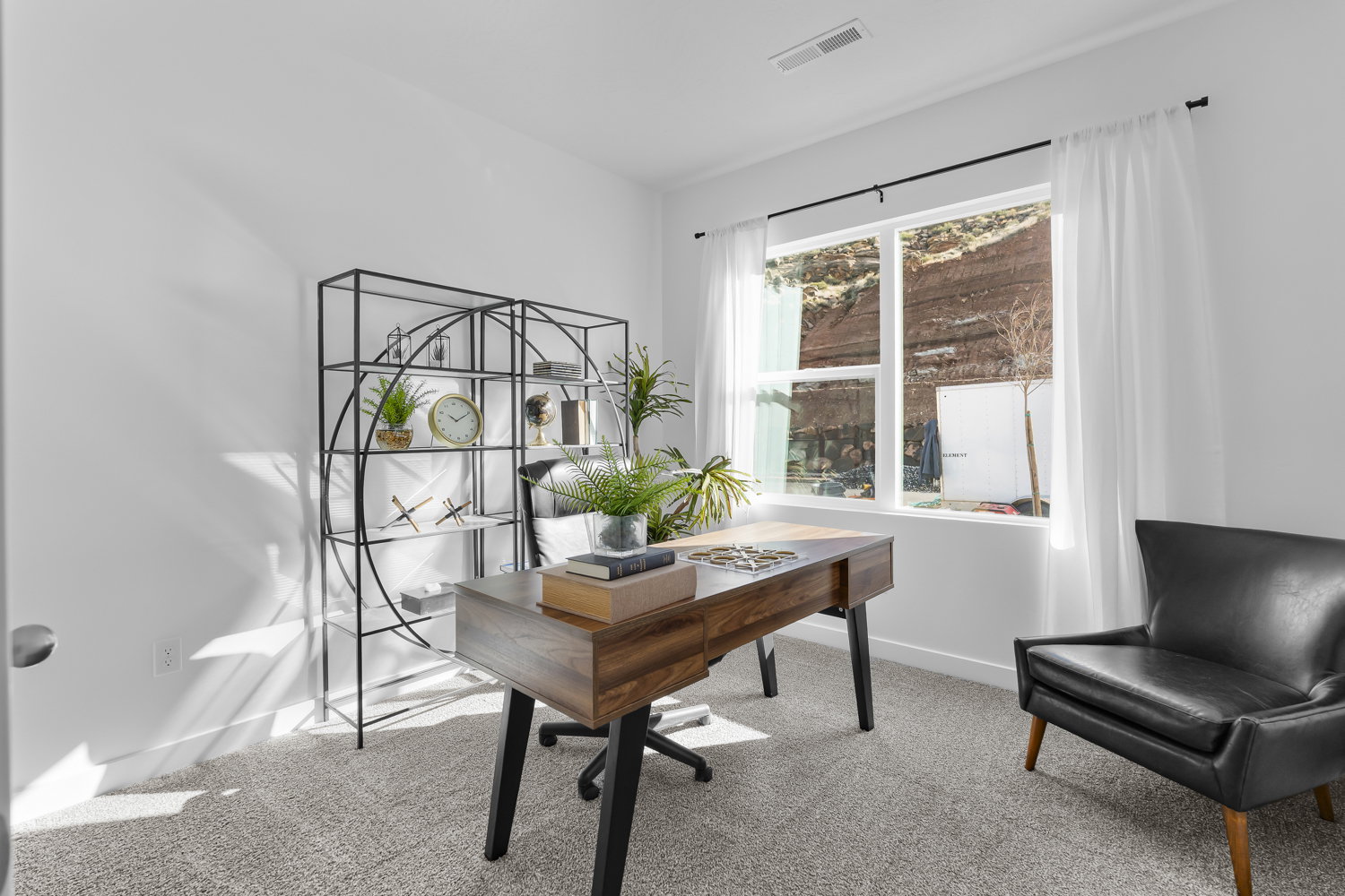 Bright interior space featuring a large window, carpet flooring, clean white walls, and a recessed ceiling vent