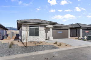 Contemporary single-story residence featuring a stone and stucco facade, a dark shingle roof, and an attached two-car garage