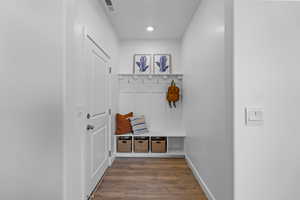 Entryway featuring a built-in bench with storage, upper shelving, and coat hooks