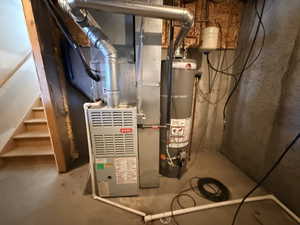 Utility area featuring a furnace, water heater, and unfinished wooden staircase