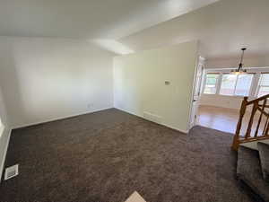 Spacious room featuring new brown carpet, white walls, and white baseboards
