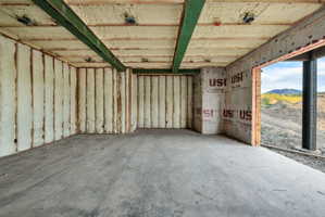 Unfinished interior space featuring exposed ceiling joists, spray foam insulation, and concrete flooring