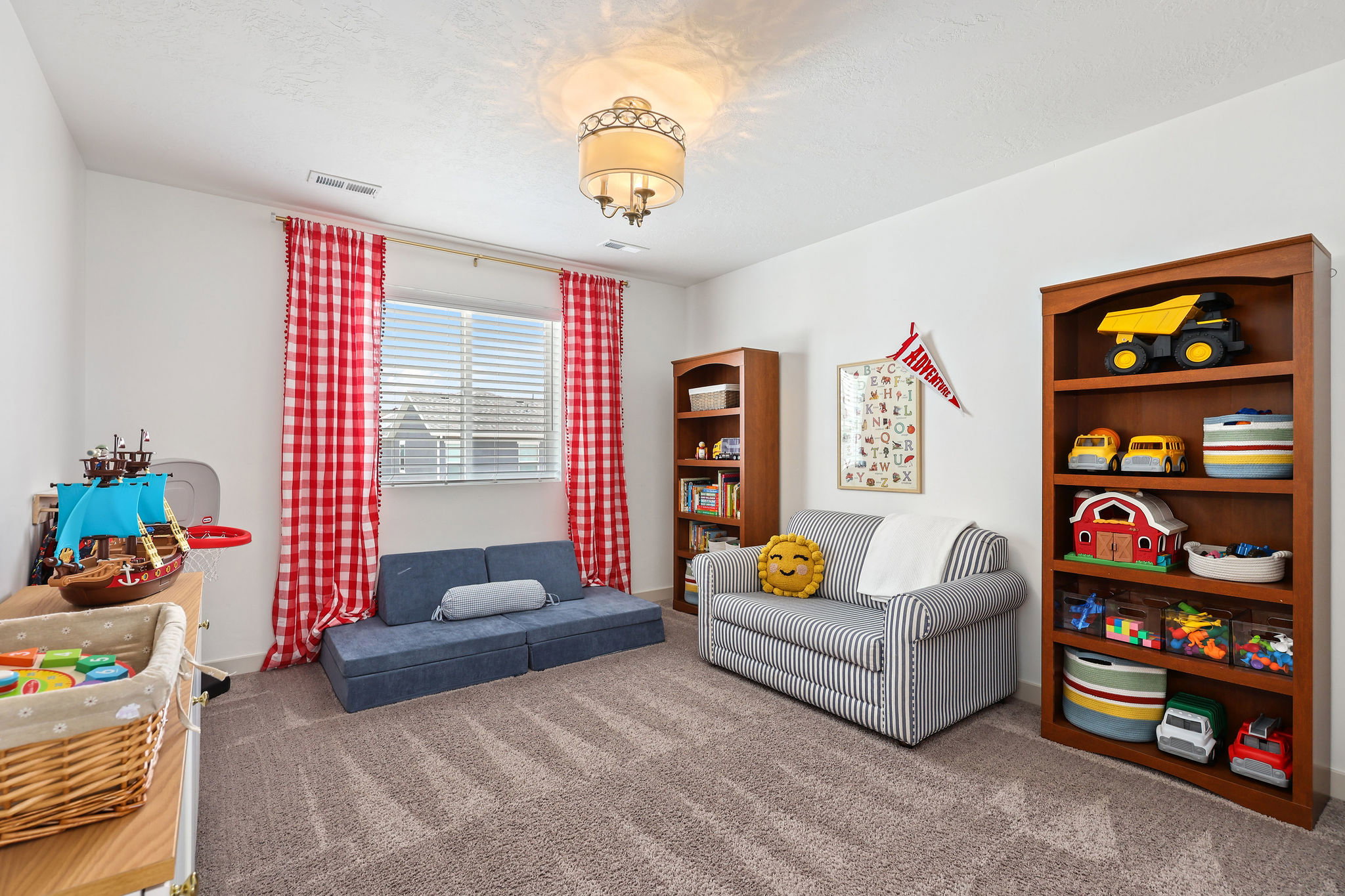 Spacious room featuring neutral carpet flooring, white walls, and a central ceiling light fixture