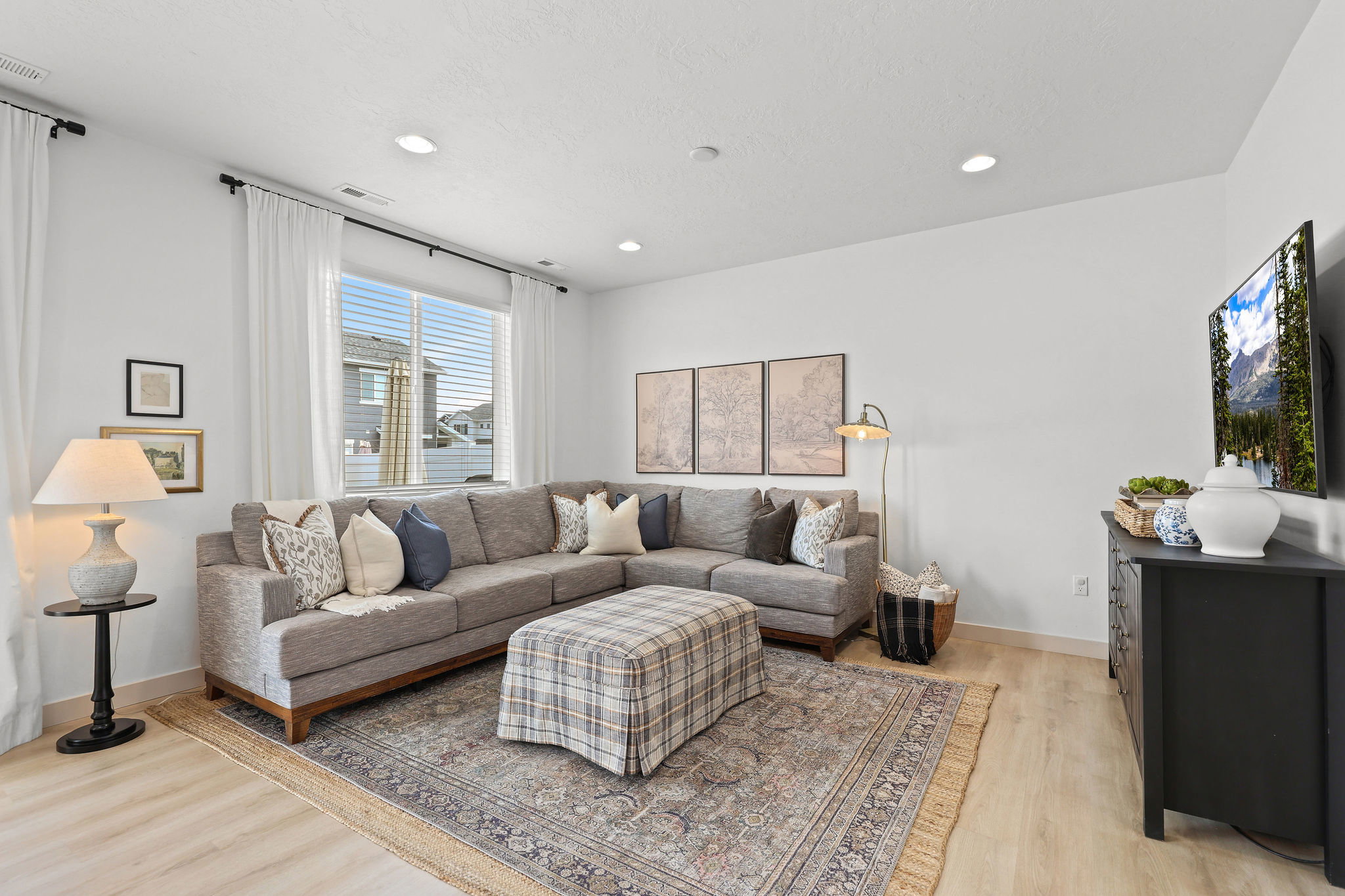 Bright living area featuring light wood-finish flooring and recessed lighting