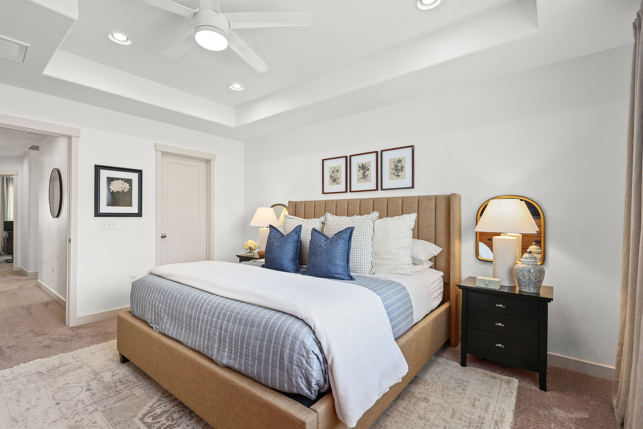 Spacious bedroom featuring a tray ceiling with recessed lighting and a ceiling fan, a neutral color palette, and carpeted flooring