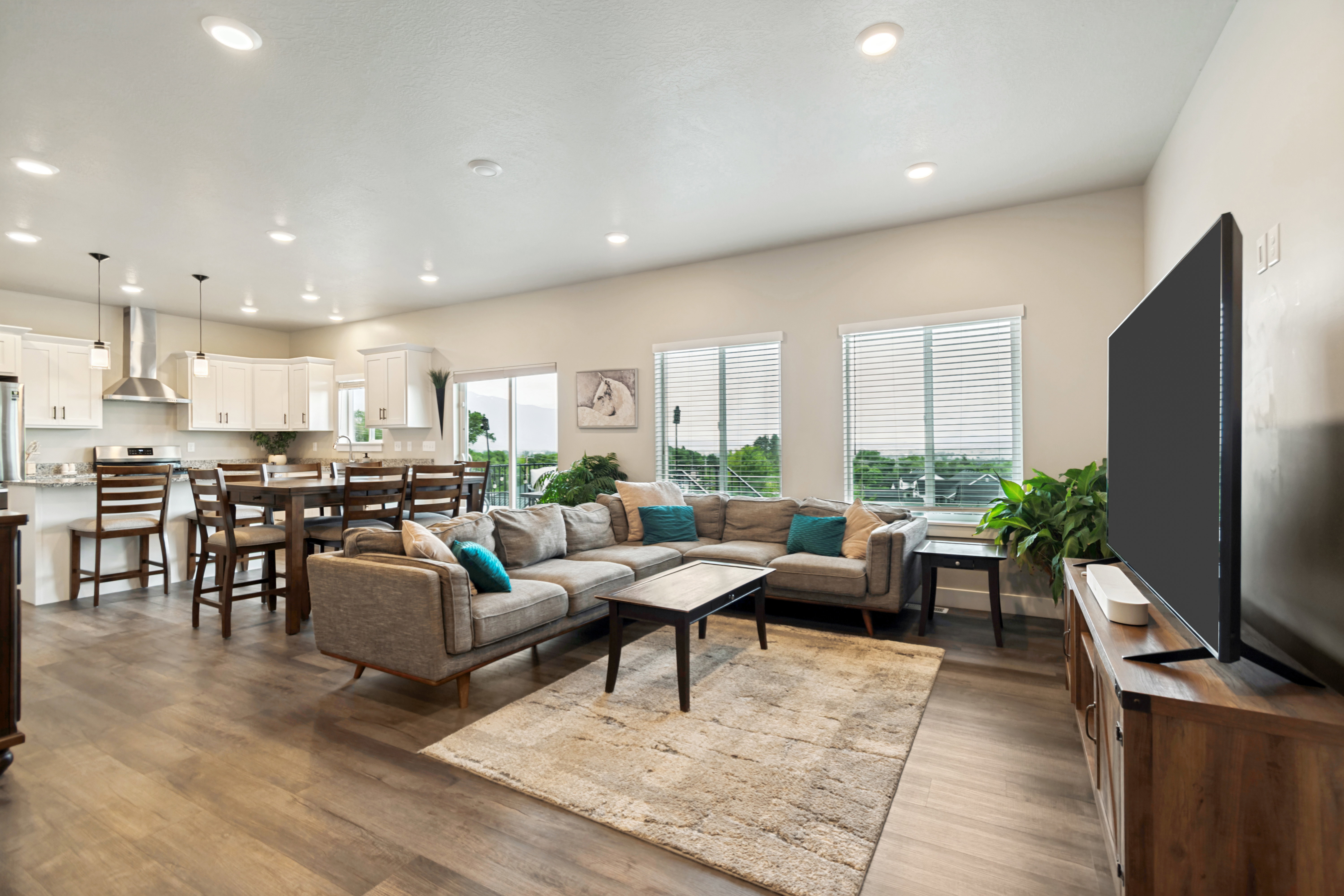 Open-concept living space featuring wood-finish flooring, recessed lighting, and ample natural light from multiple windows