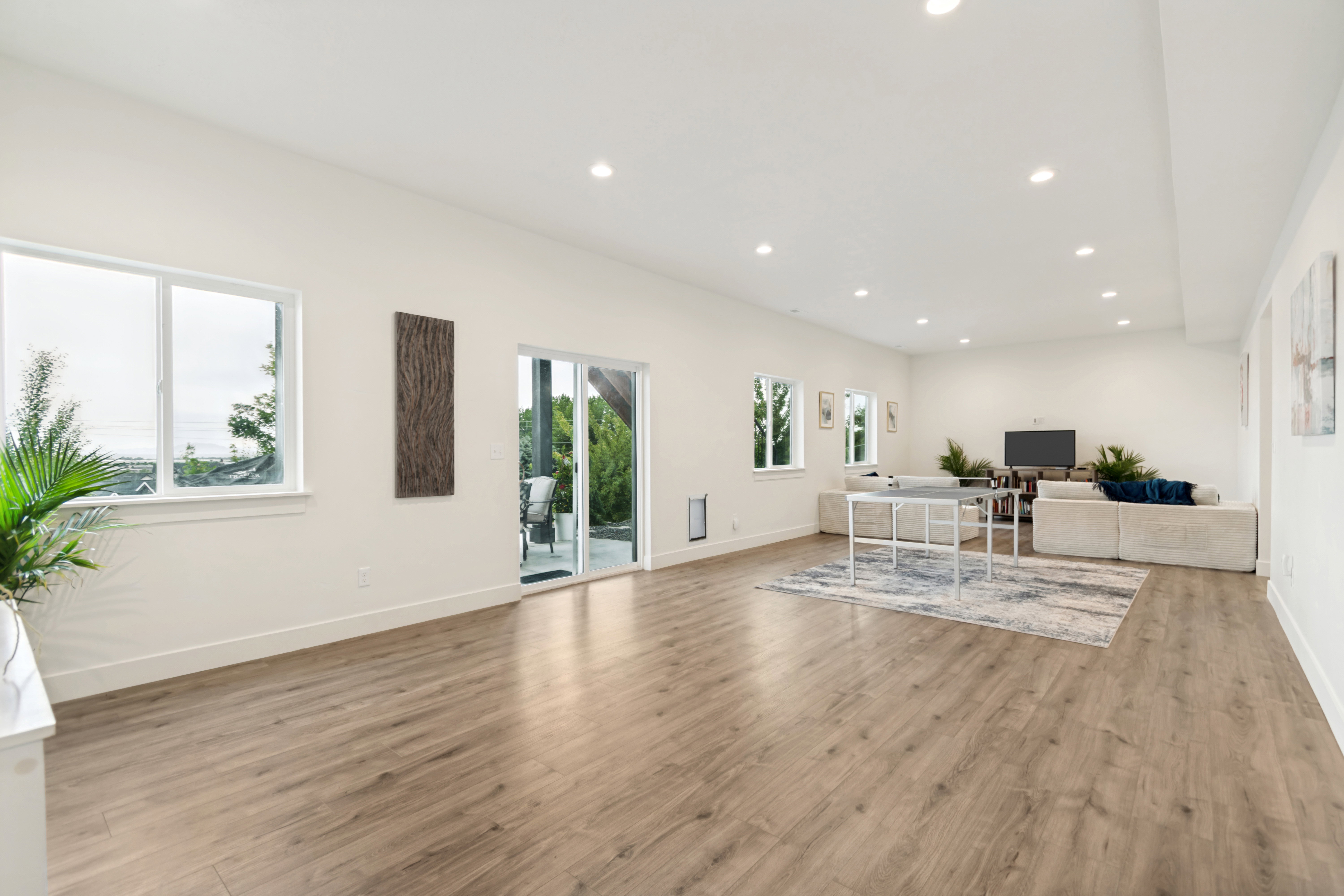 Spacious interior featuring wood-finish flooring, recessed lighting, multiple windows, and a sliding glass door to an outdoor area