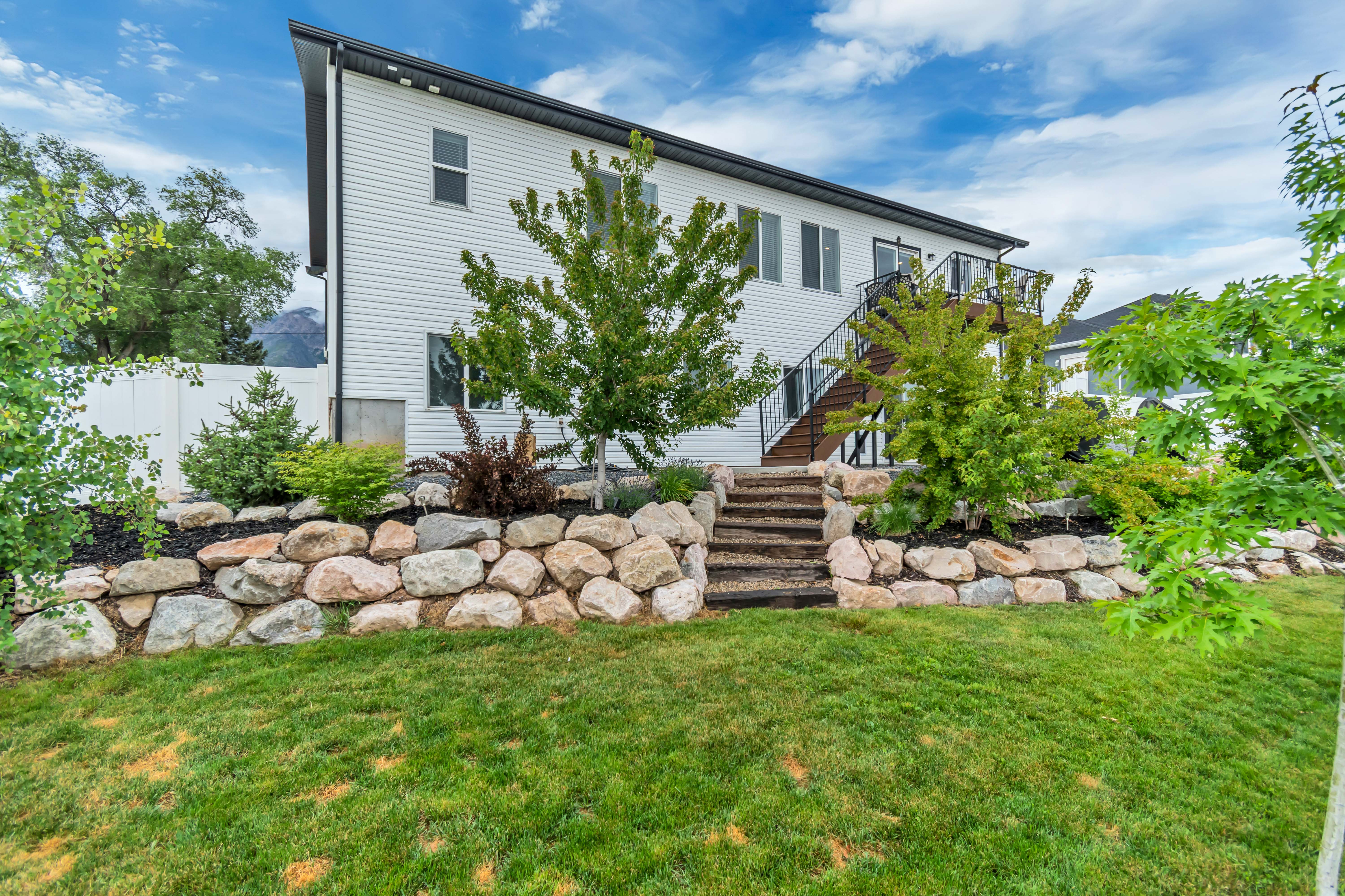 Rear exterior featuring white siding and a black-framed second-story deck