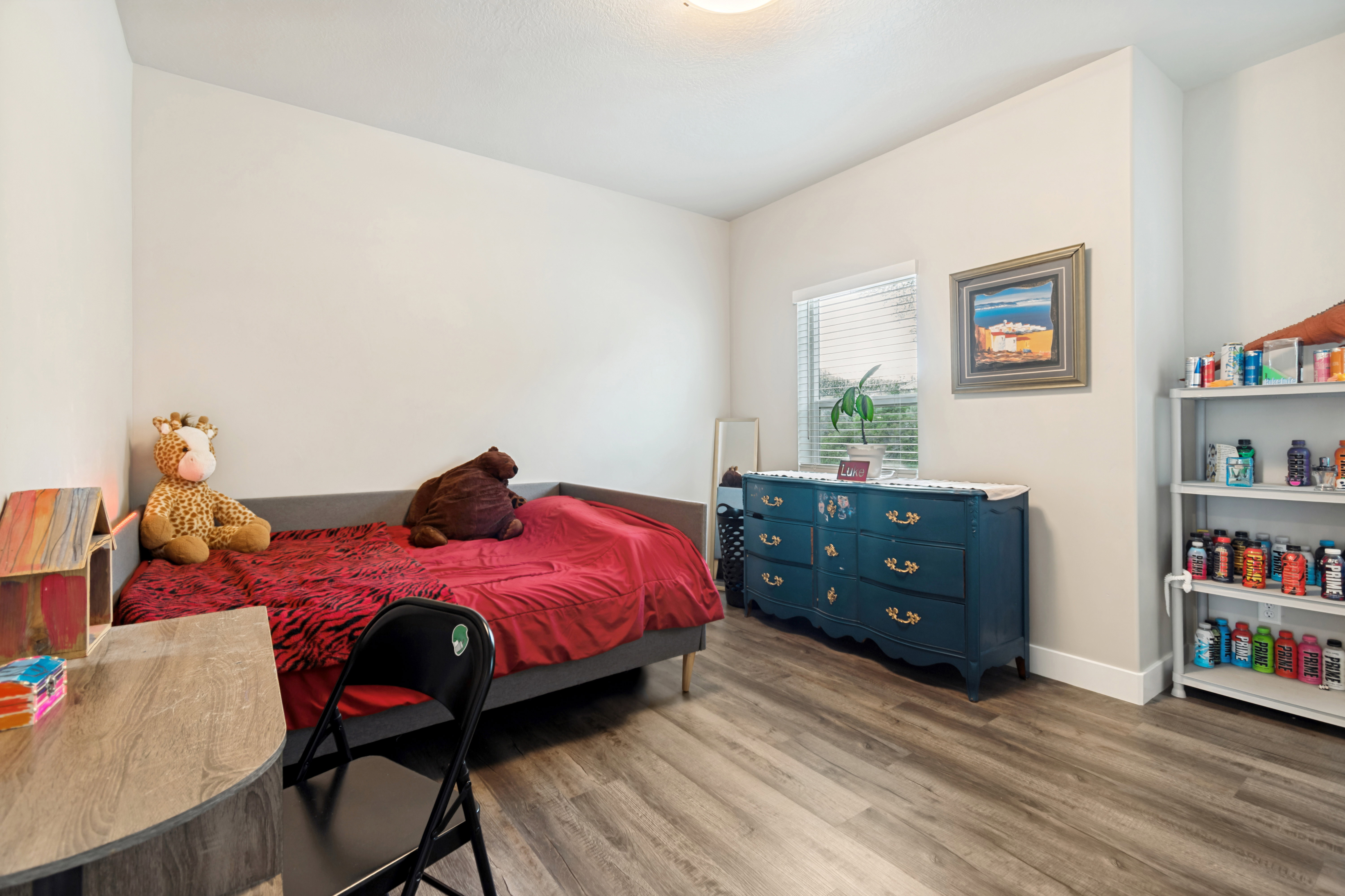 Neutral wall color in a room featuring wood-finish flooring