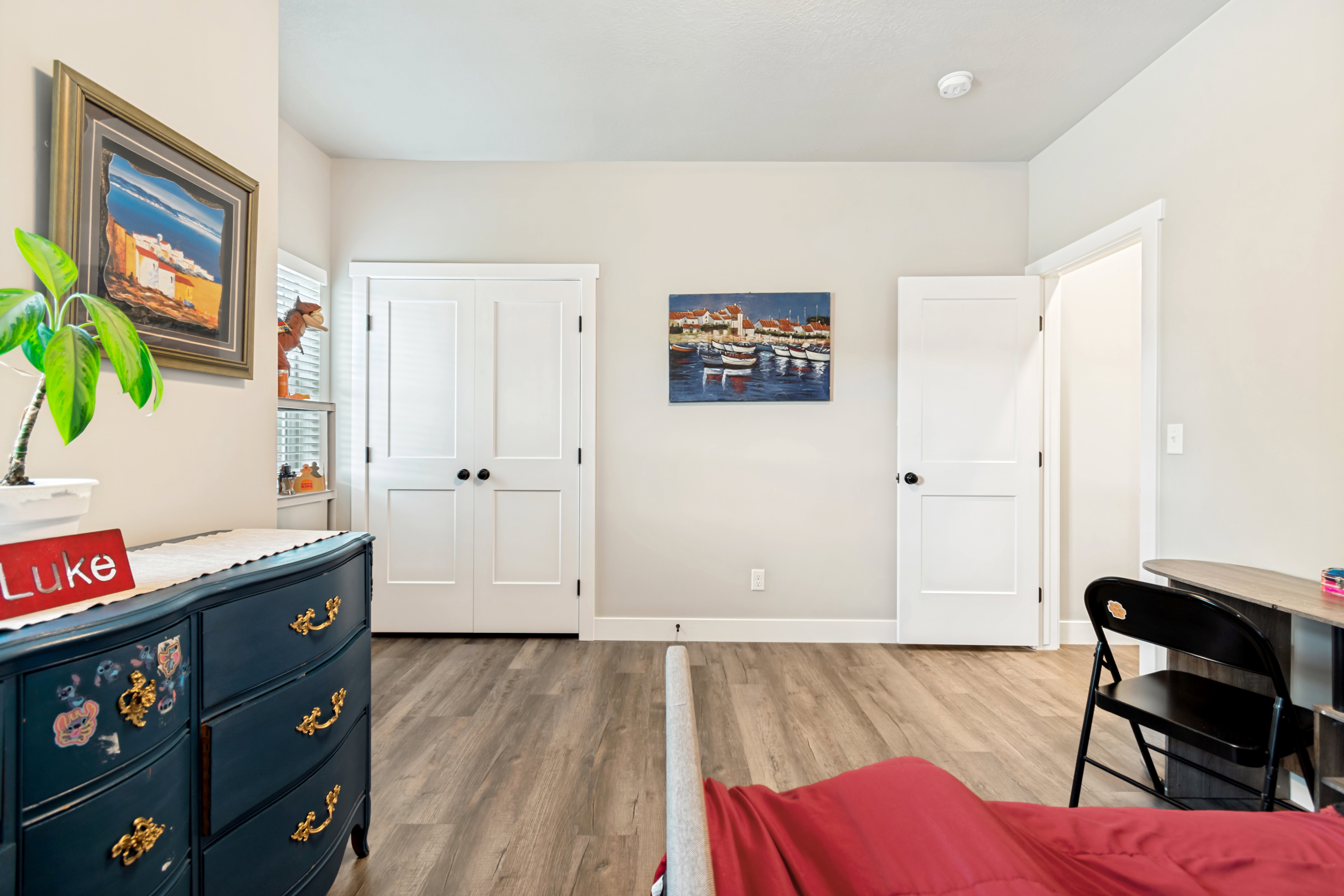 Neutral wall paint with white trim, wood-finish flooring, and white two-panel doors